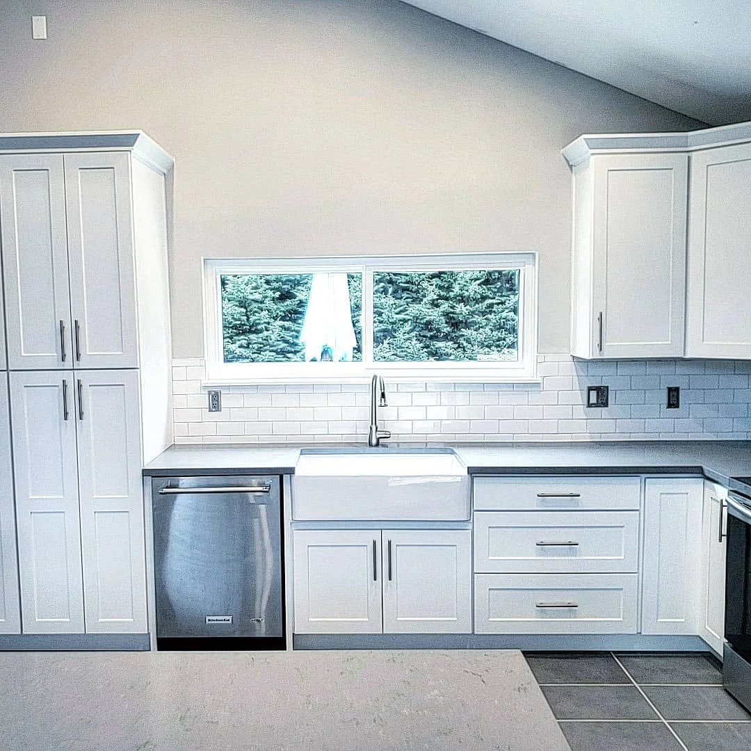 Elegant Newcastle kitchen remodel with bright white cabinets and white subway tile backsplash. Elegant stainless steel hardware finishes.