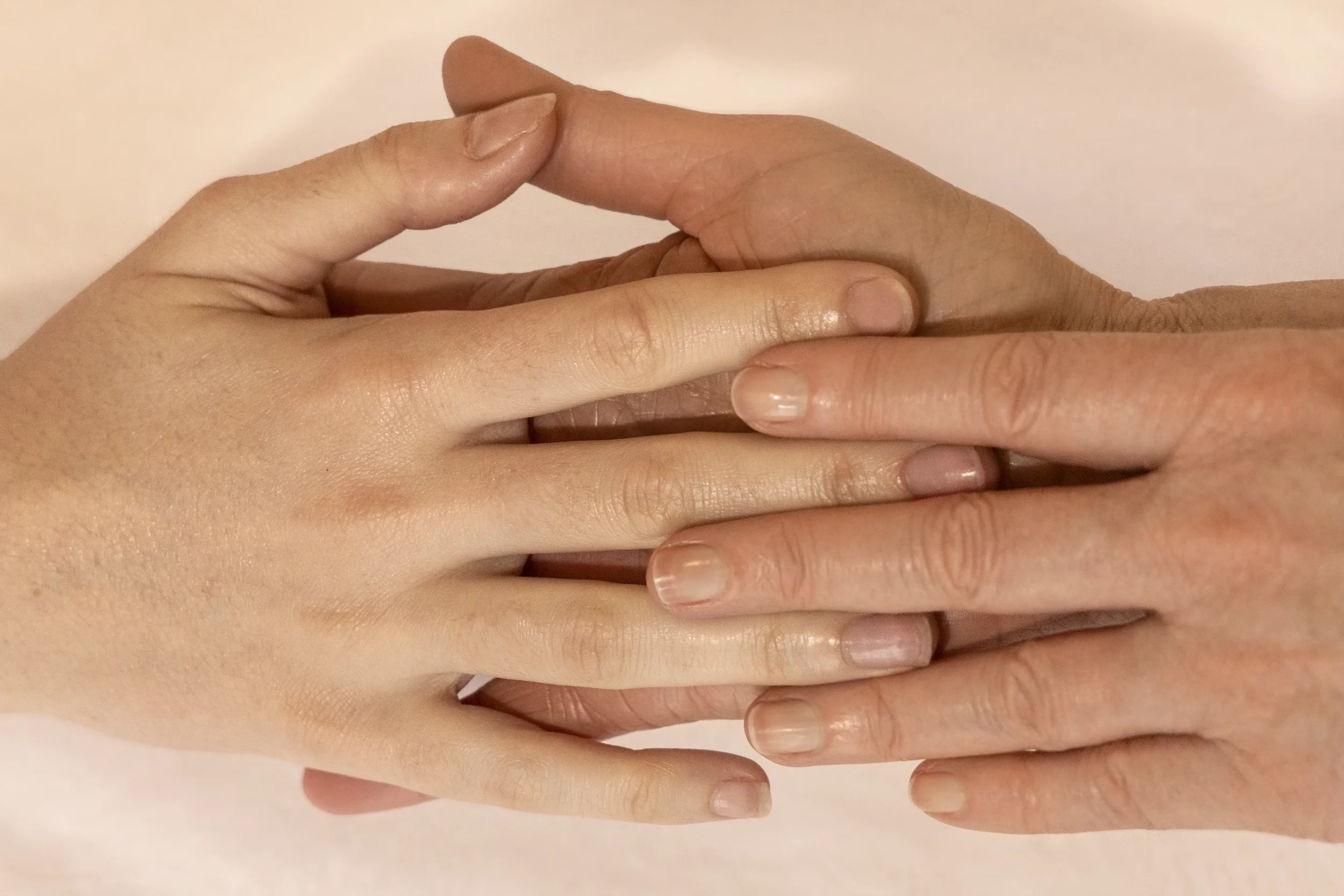 Deux mains, une claire et une foncée, qui se touchent doucement.