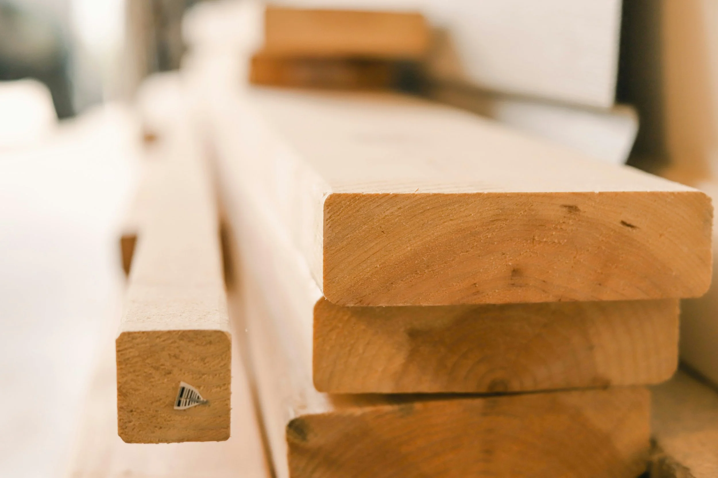 Cuatro tablas de madera apiladas en un taller o carpintería.
