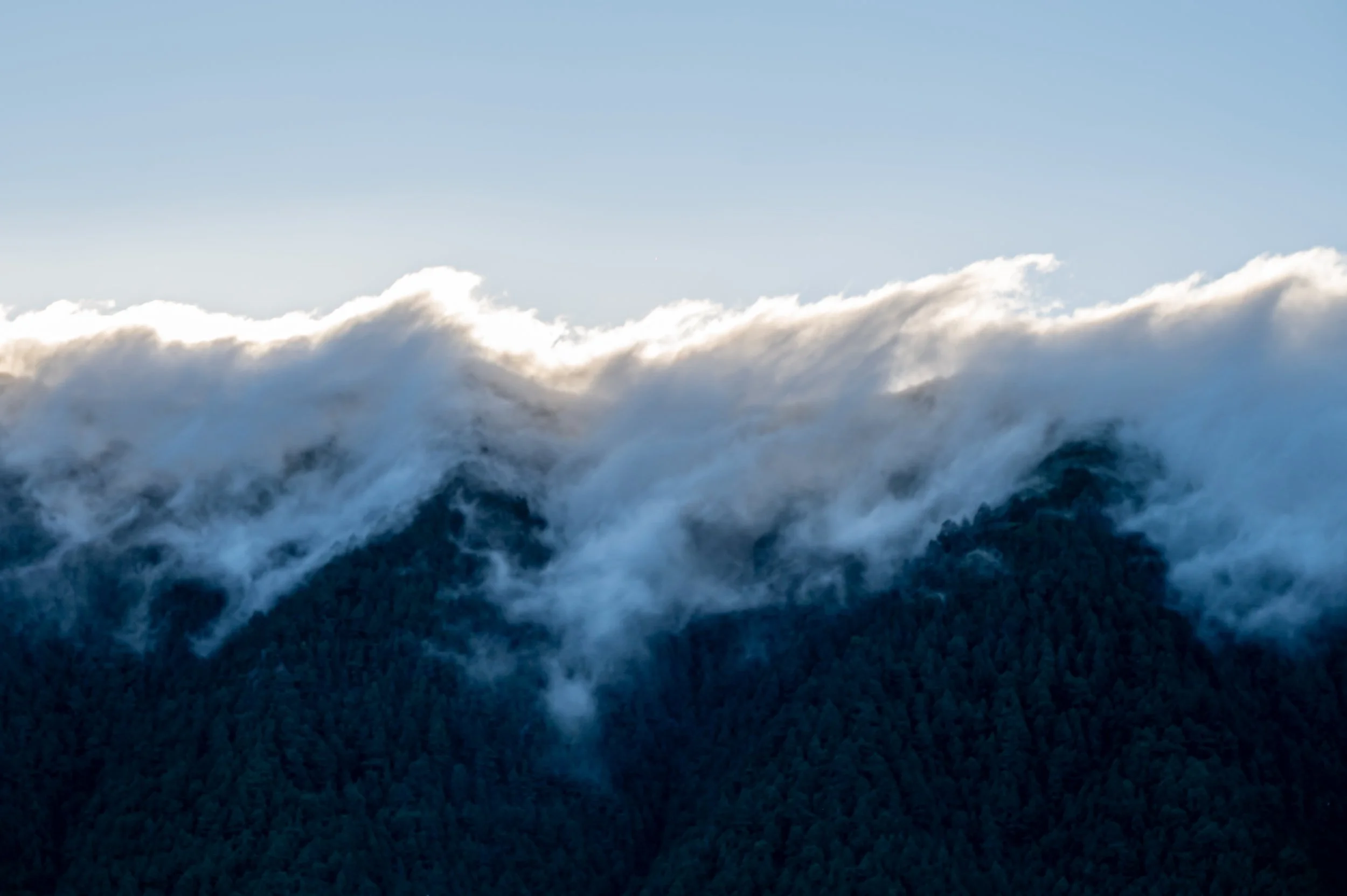 Clouds bending over the top of the mountains