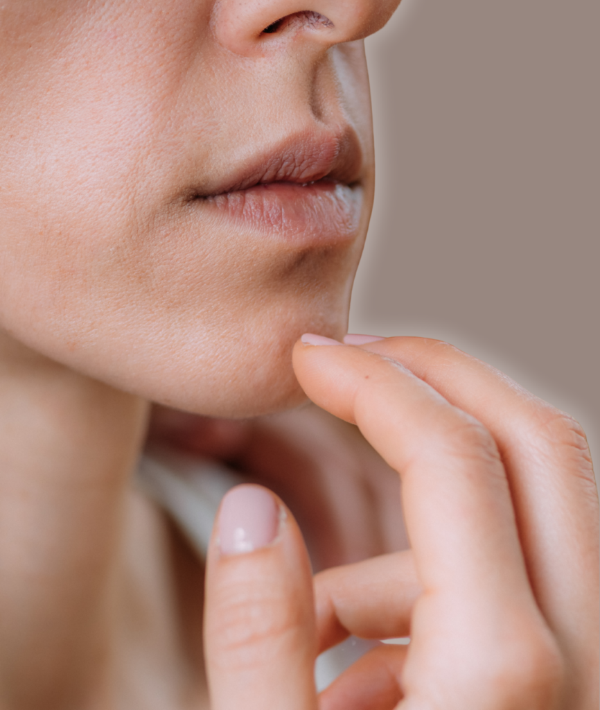 Close-up of a woman touching her lips with her finger.
