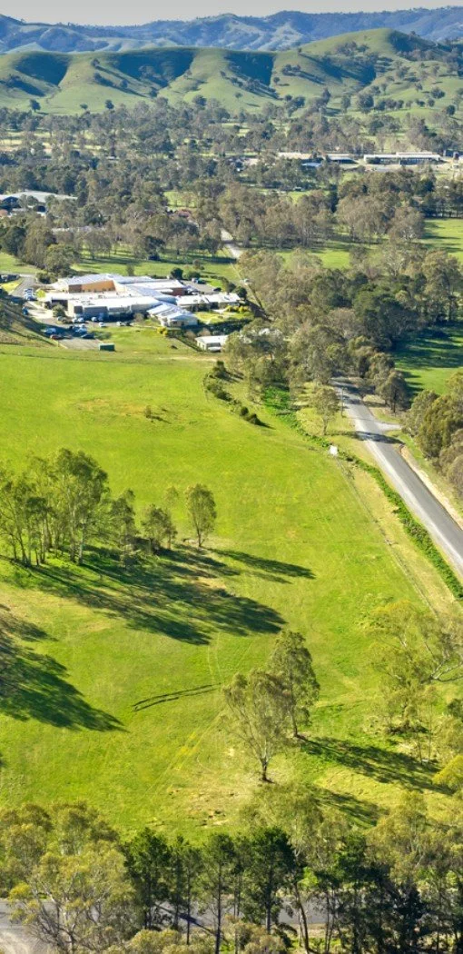 Aerial view of Woodlands Grove estate in Alexandra, framed by rolling green hills