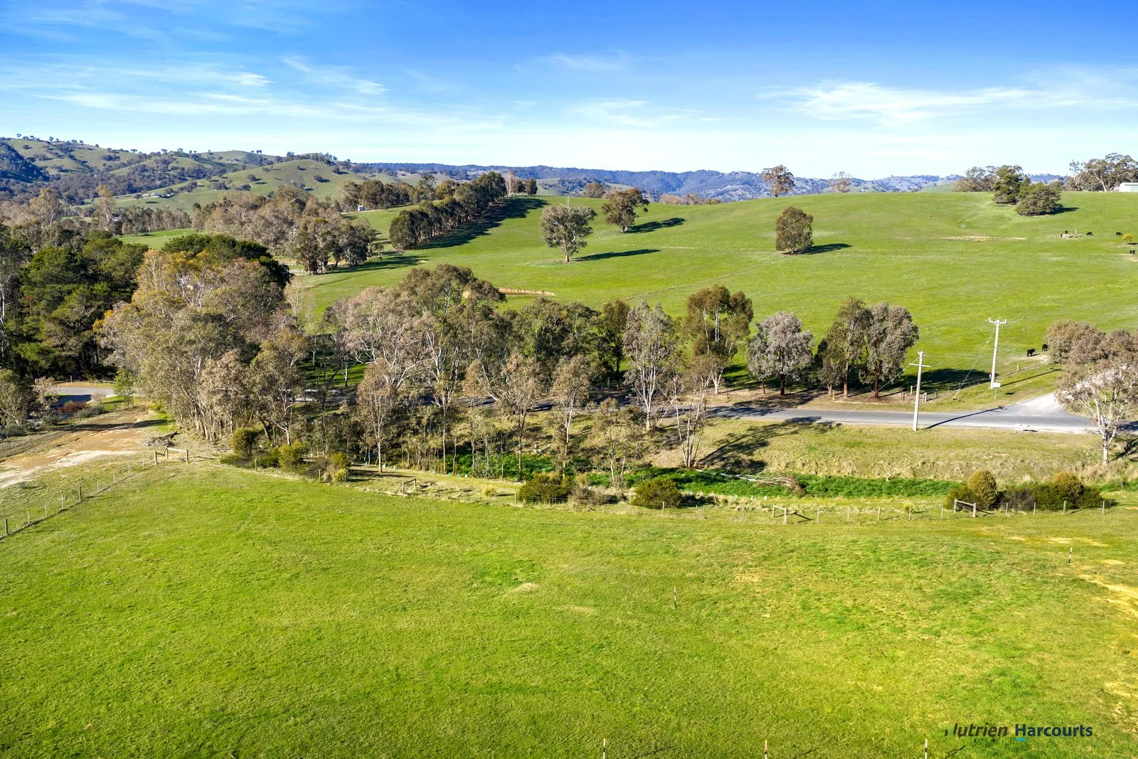 Open grassland at Woodlands Grove with Alexandra township and hills beyond
