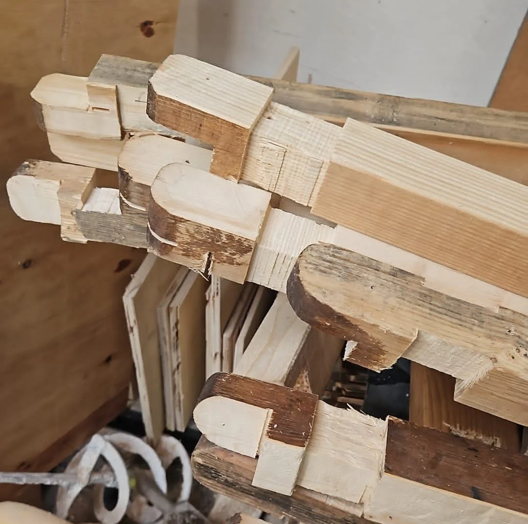 Stack of various cut wooden pieces with different shapes and sizes.