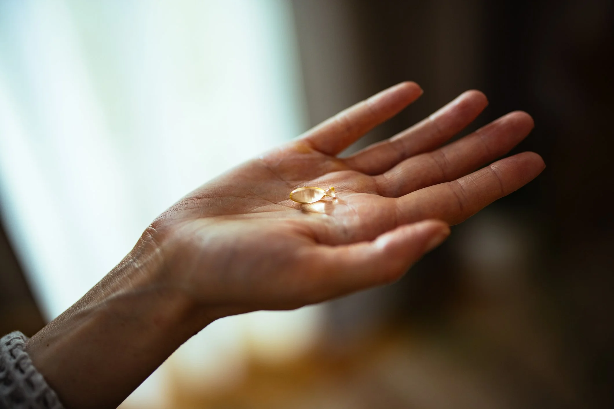 Hand holding selected micronutrient supplements representing personalised, evidence-based preventive medicine and Healthy Aging programmes at DR GRŪN private medical practice in Berlin.