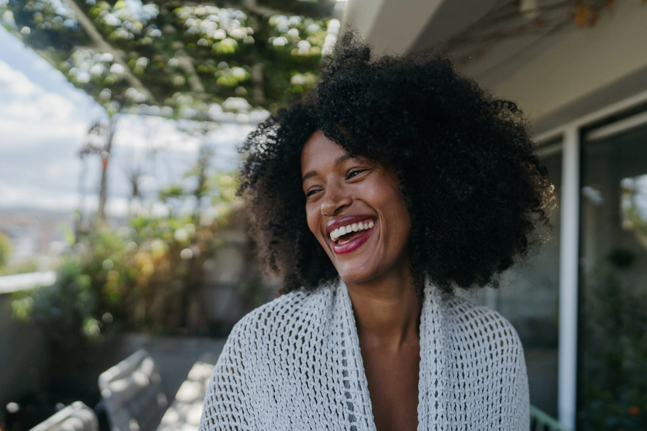 Healthy, Smiling woman representing confidence, wellbeing and personalised patient-centered healthcare at DR GRÜN private medical practice in Berlin.