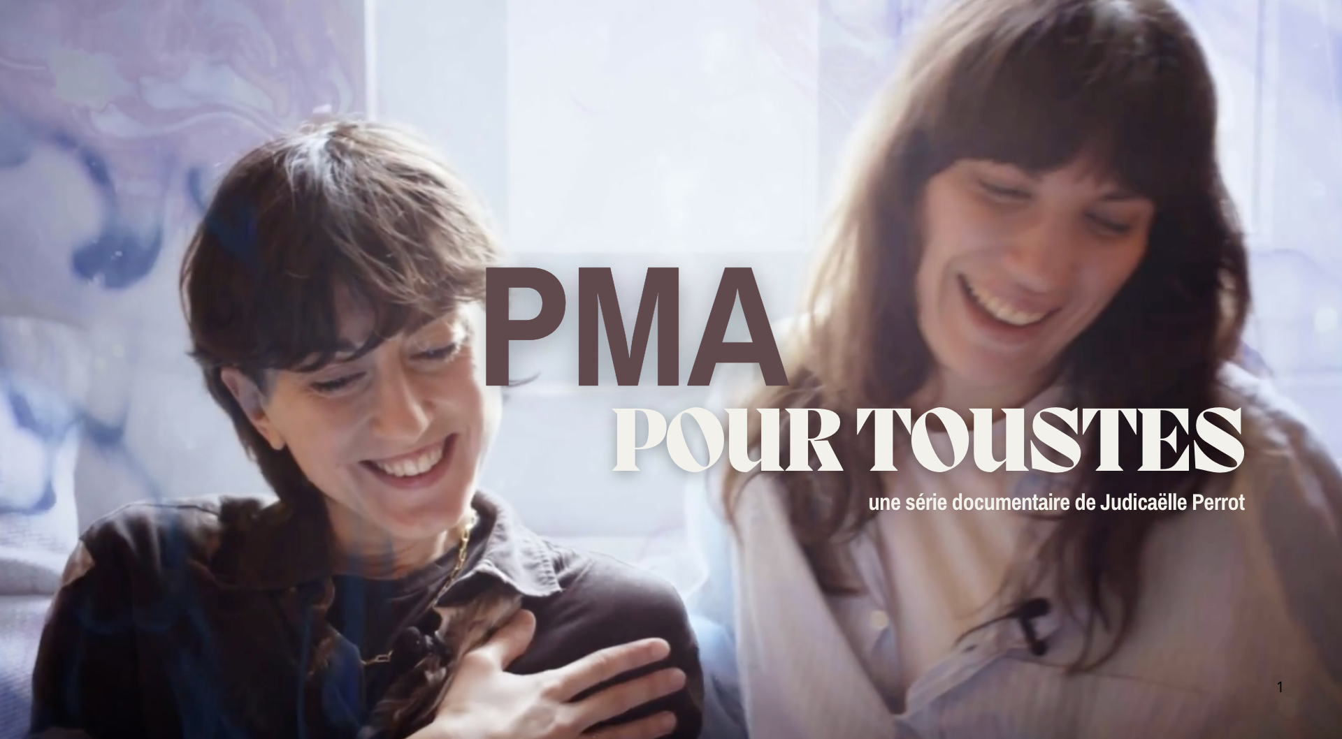 Deux personnes souriantes, un garçon et une femme, regardant quelque chose avec amusement, dans un espace lumineux