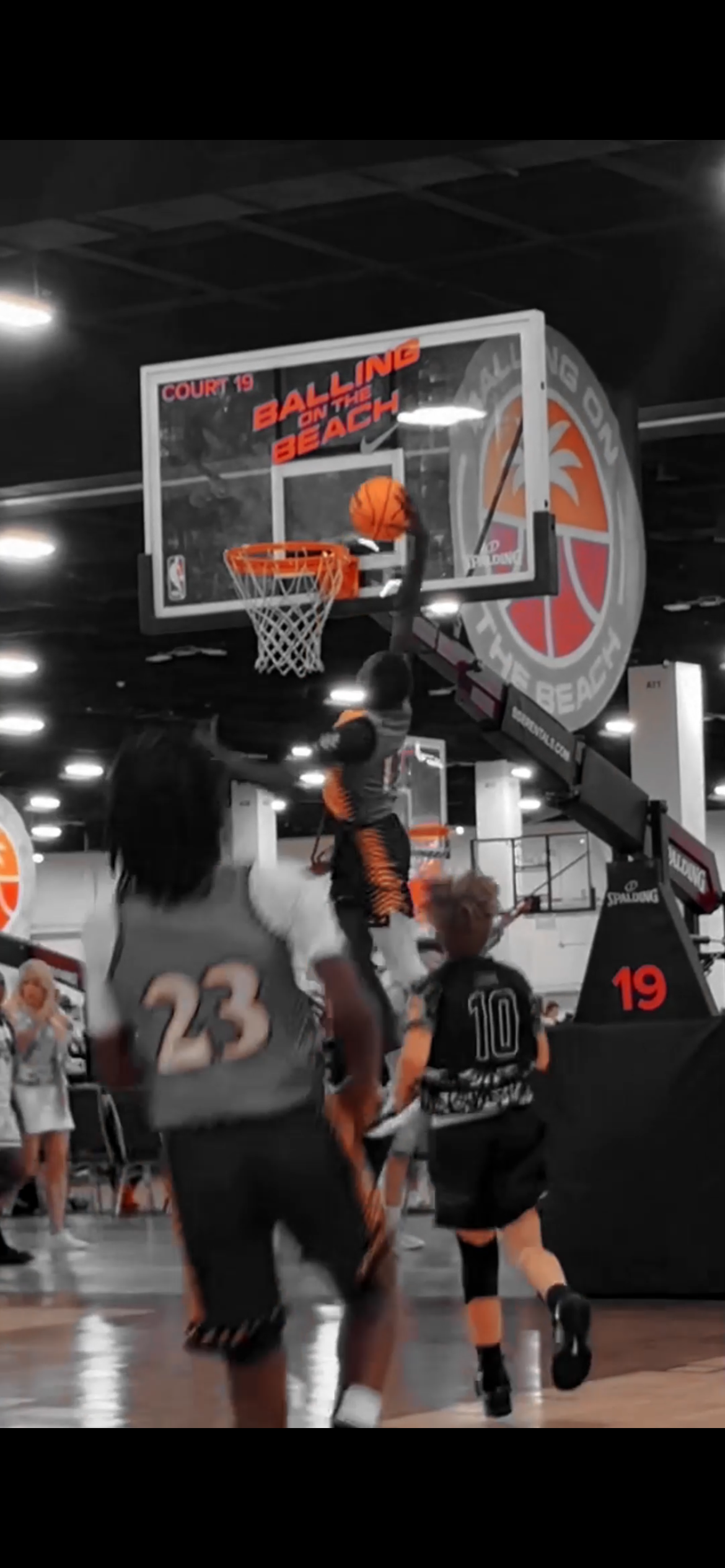 Kids playing basketball in an indoor gym, with a basketball going through the hoop, labeled 'Ball on the Beach'.