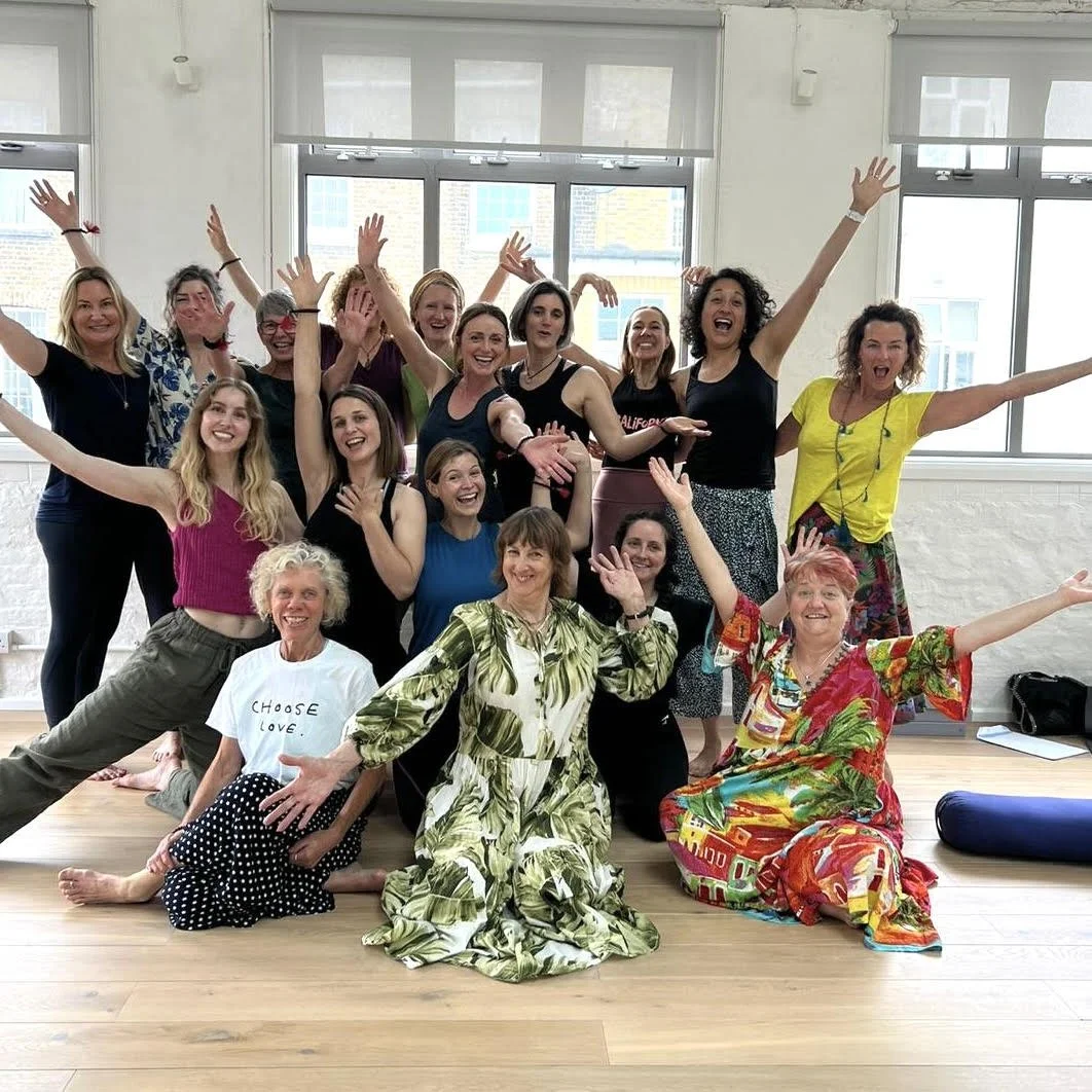 Group of women smiling and celebrating in a bright room with large windows