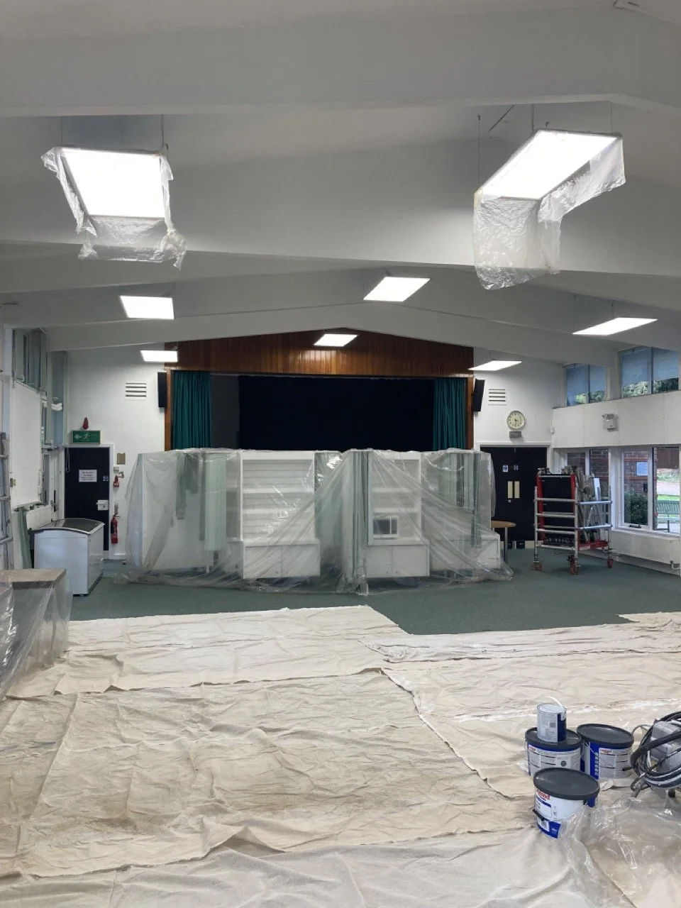 Commercial decorating project showing prepared walls and flooring protection.
