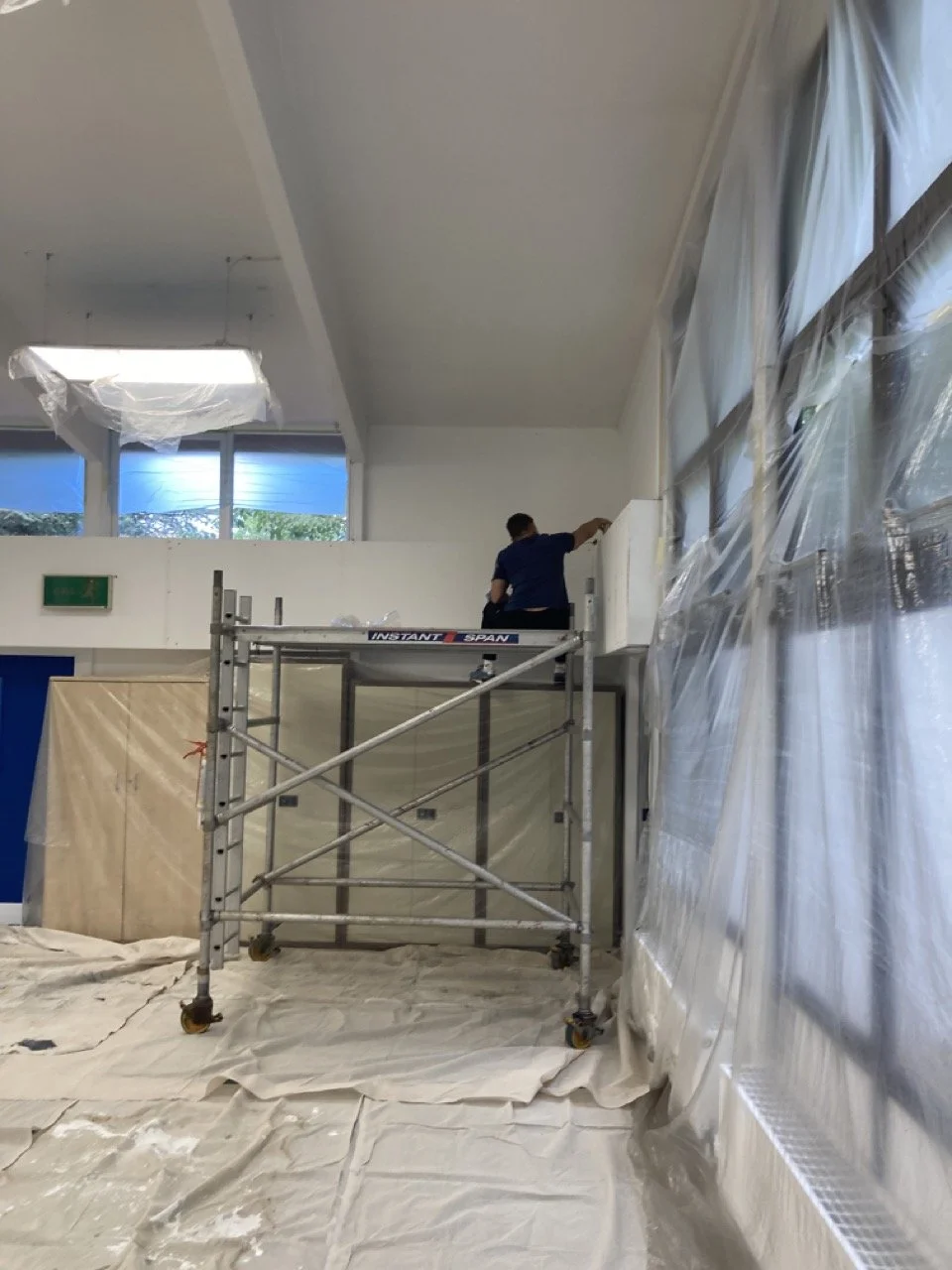 Commercial unit decoration nearing completion with preparation materials in use, showing a clean white interior finish.