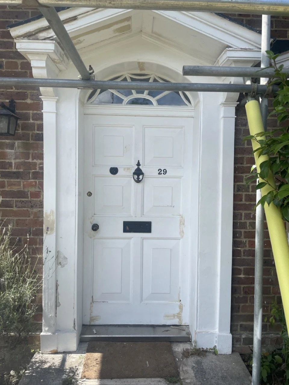 Residential front door and window area before exterior restoration.