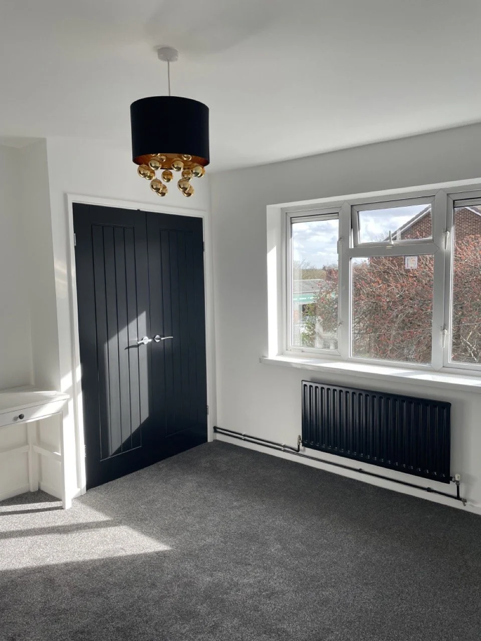 Restored bedroom interior, professional painted detail on doors and radiators for clean, modern decorative finish.