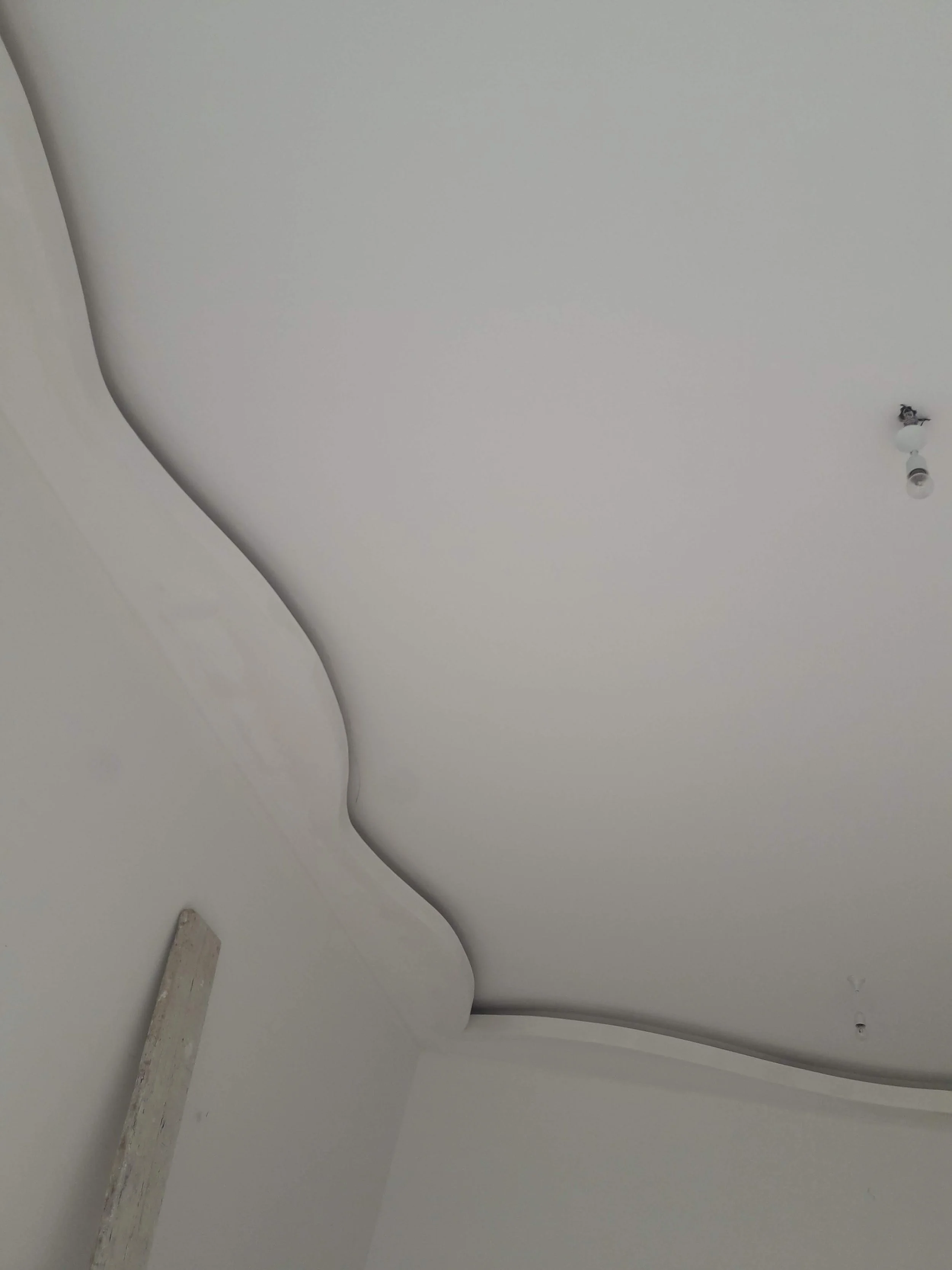 Ceiling with curved crown molding and a bare light bulb socket