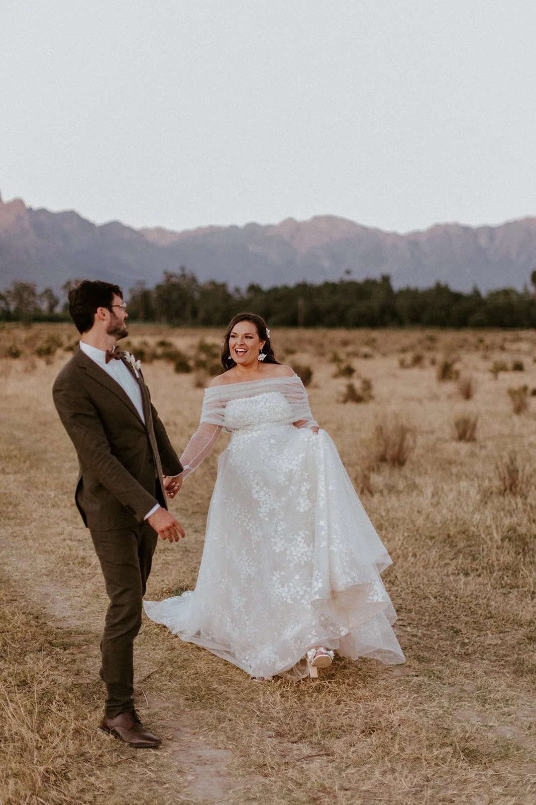 Bride and groom holding hands during their wedding portrait session at Montpellier Wine Estate in Tulbagh.