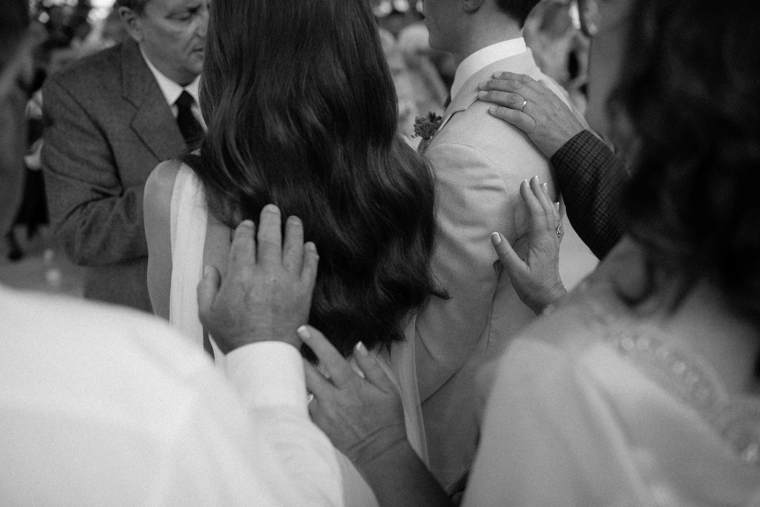 Bride and groom surrounded by their parents as the priest blesses their marriage during their ceremony at Olijvenkraal Olive & Wine Estate.