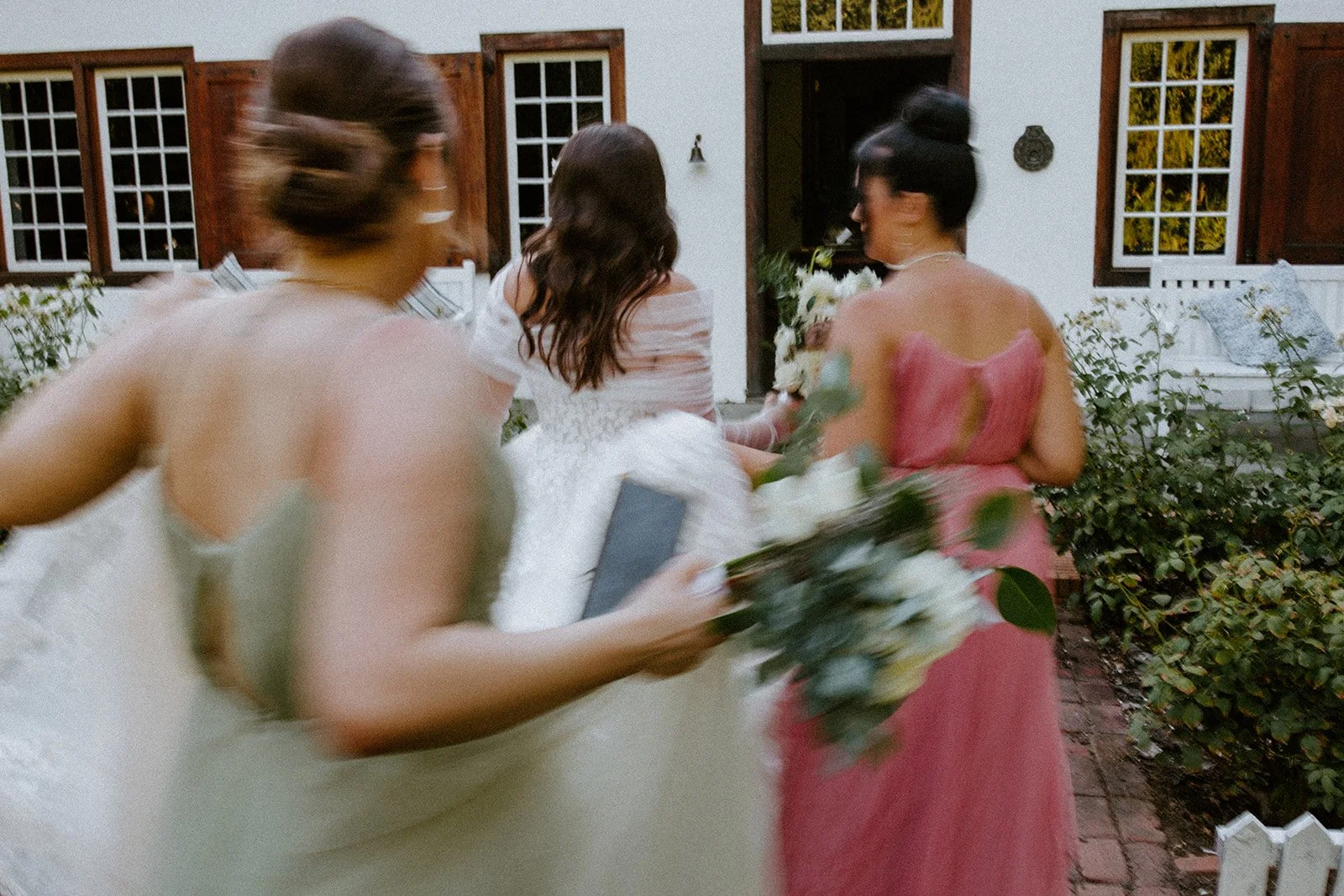 Bride and bridesmaids walking through the courtyard at Montpellier Wine Estate before the ceremony.