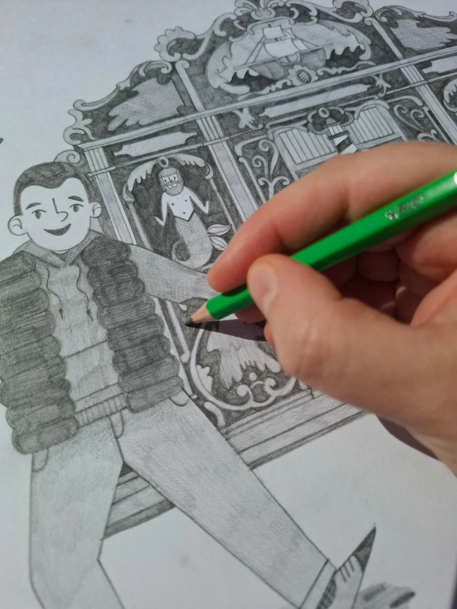 Process photo of a hand sketching a character in front of an ornate street organ with a green colored pencil.