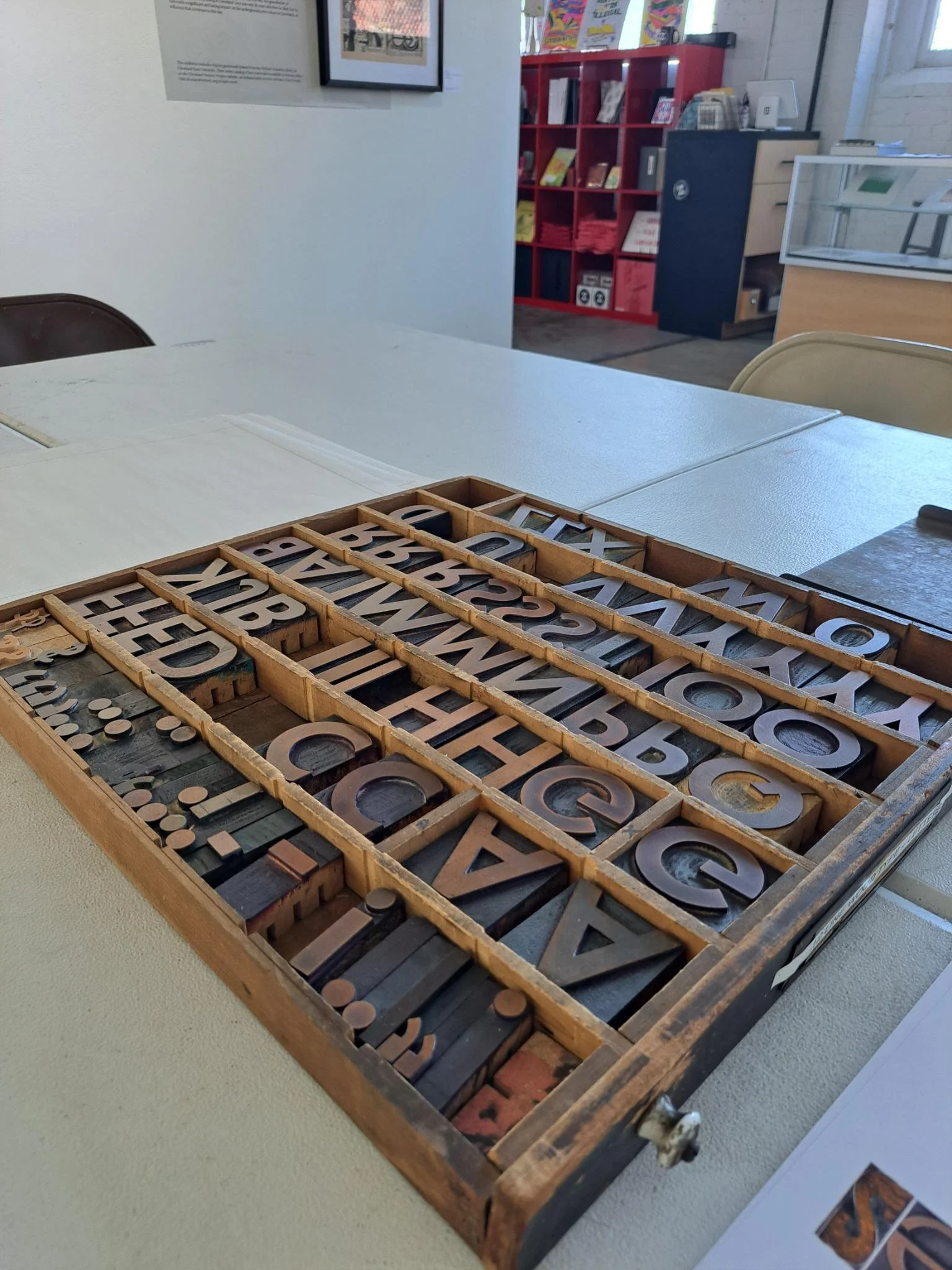 Photograph of vintage wooden letterpress type arranged in a printer’s drawer inside an art studio.