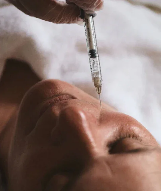 Close-up of a woman receiving a non-surgical aesthetics treatment to her face