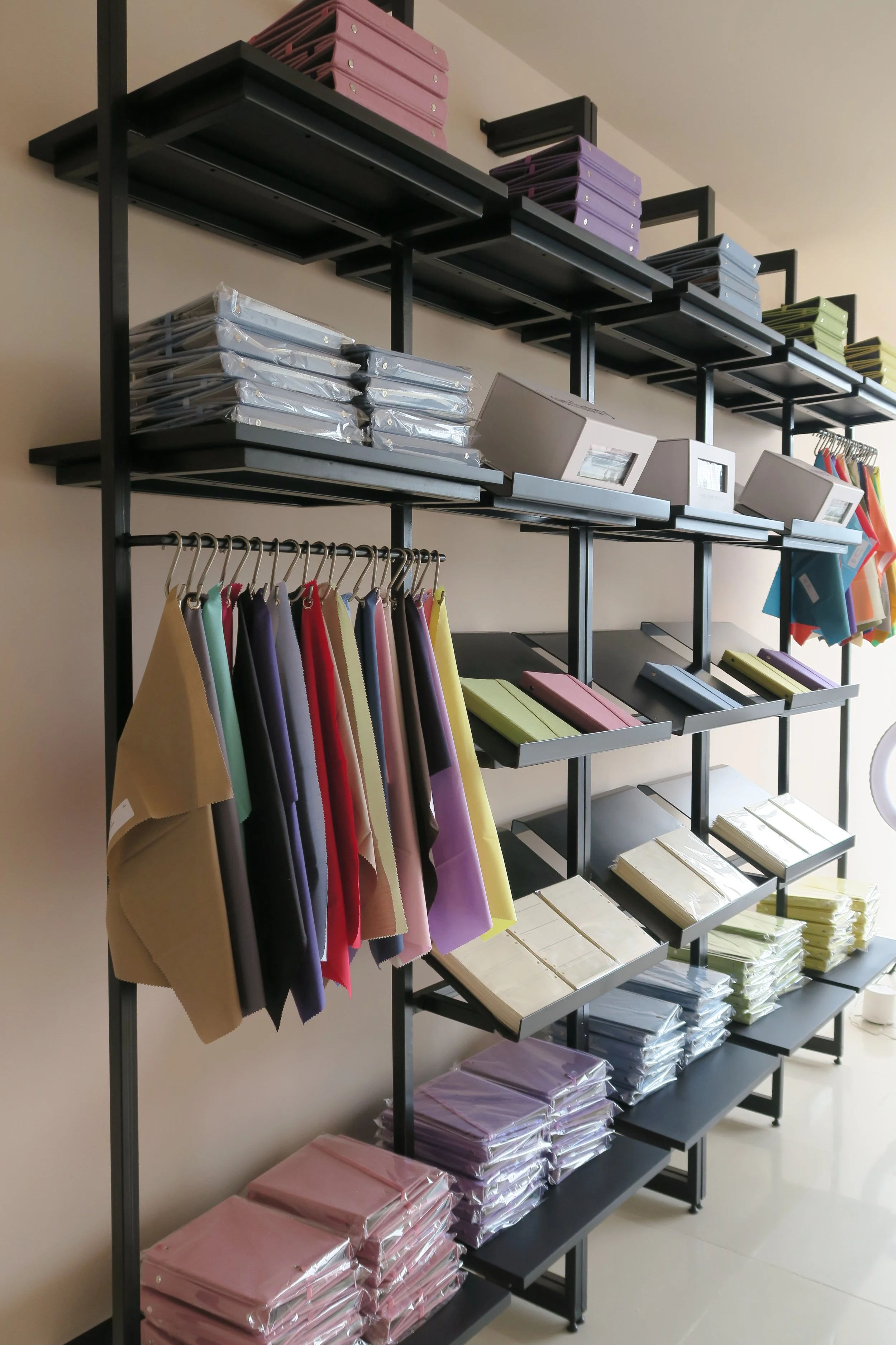 Display shelf with fabric samples, folders, and swatches in a store or showroom.