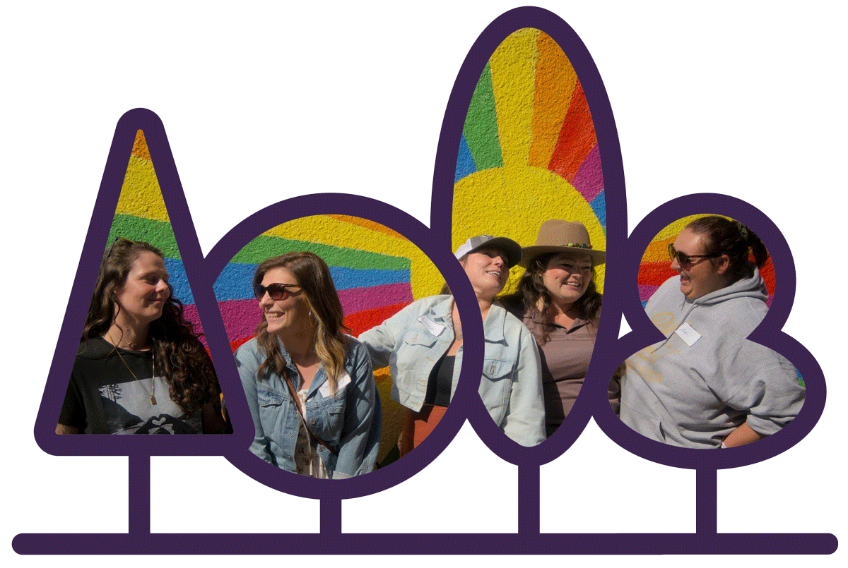 Guests in front of a rainbow mural on tour, in a cut out of trees.