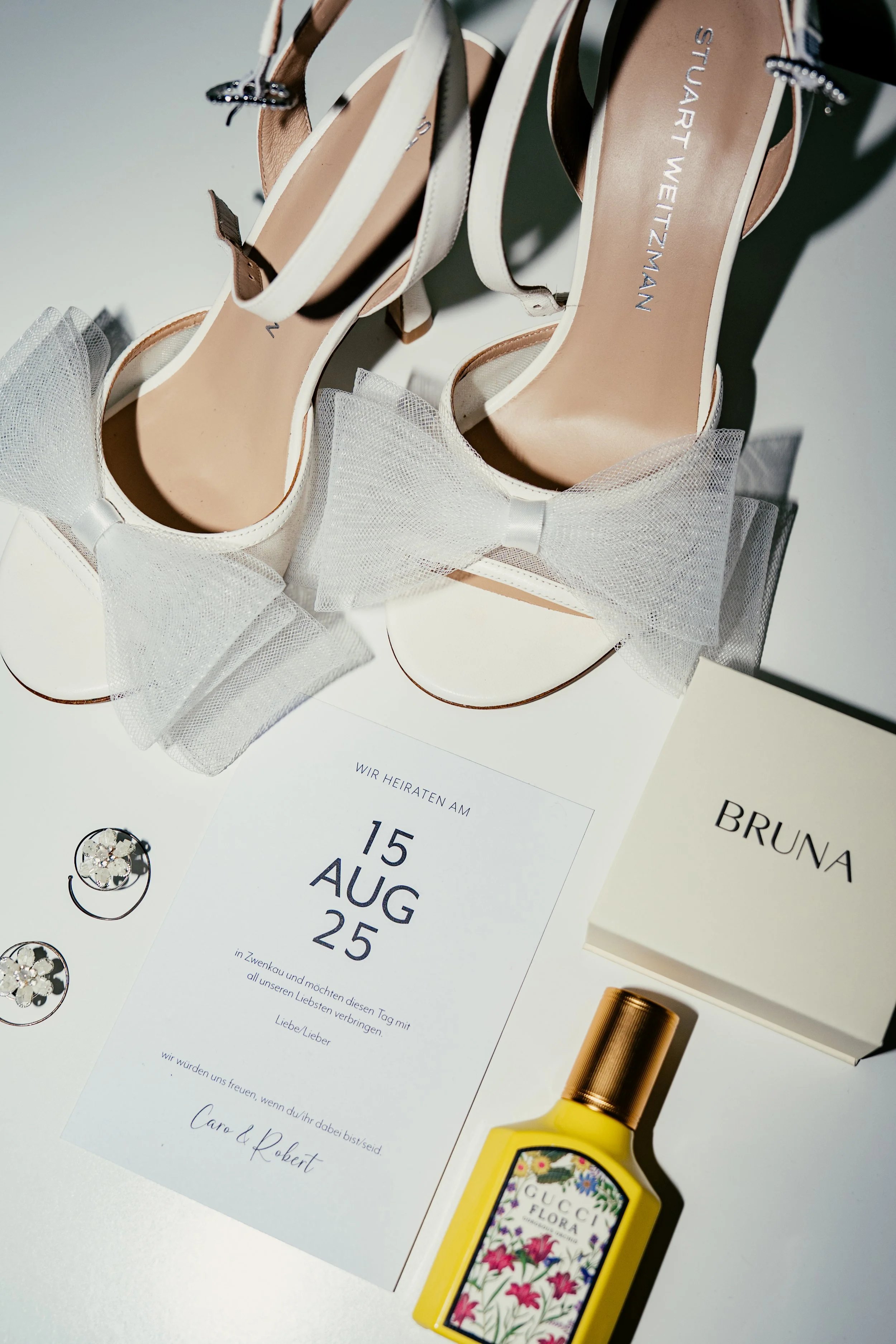 Hochzeitseinladungen, Brautschuhen mit Spitze und Schleife, Schmuck, Parfümflasche und Geschenkbox