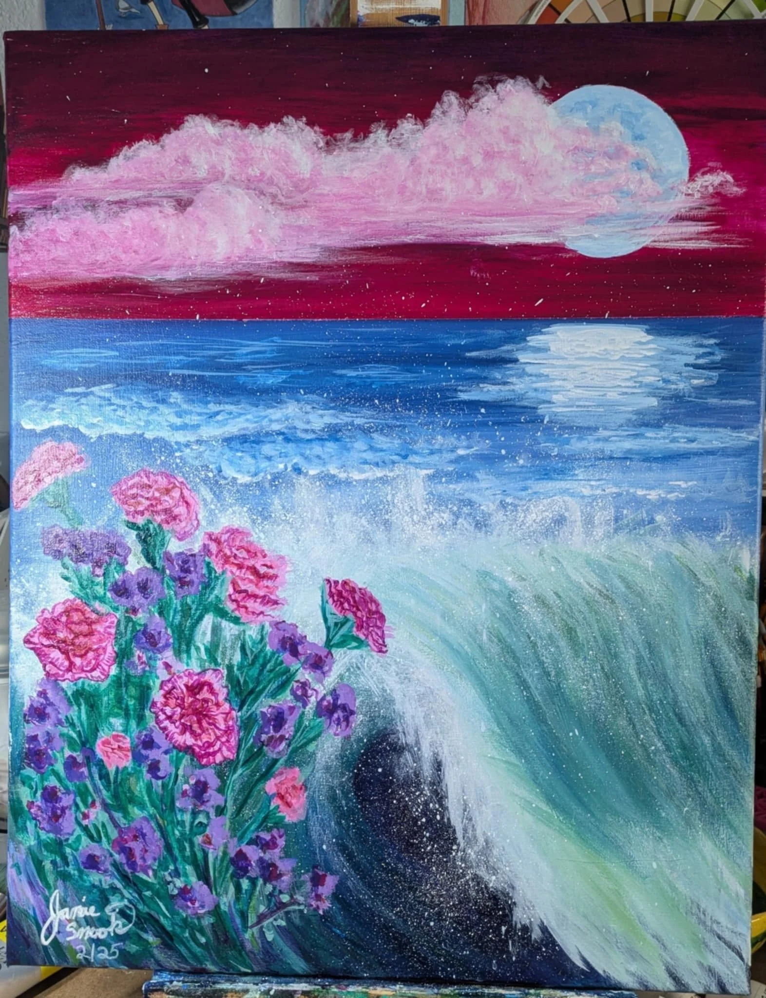 A painting of a purple and blue ocean under a pink and dark red sky with a large blue moon and pink flowers in the foreground.