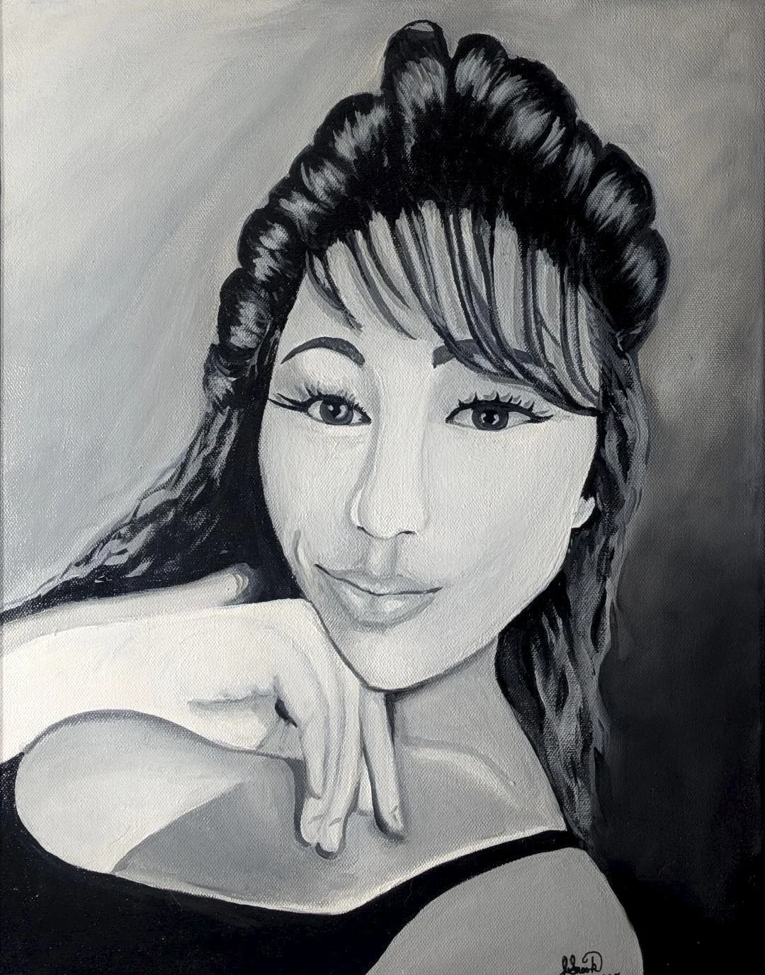 Black and white portrait of a woman with styled hair, resting her chin on her hand, wearing a sleeveless top.