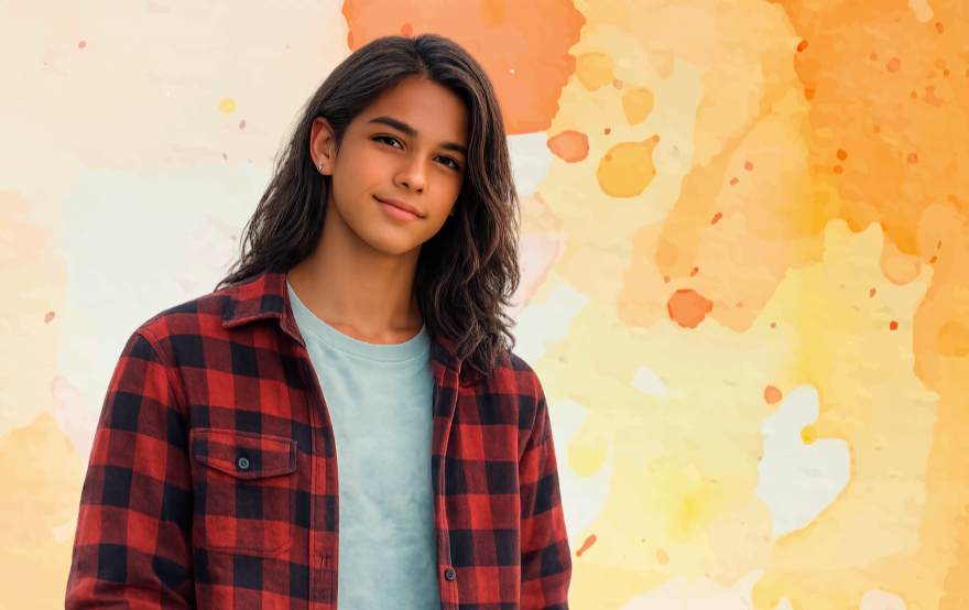 Young woman with dark hair wearing a red plaid shirt and light blue t-shirt, standing against an abstract orange and yellow watercolor background.