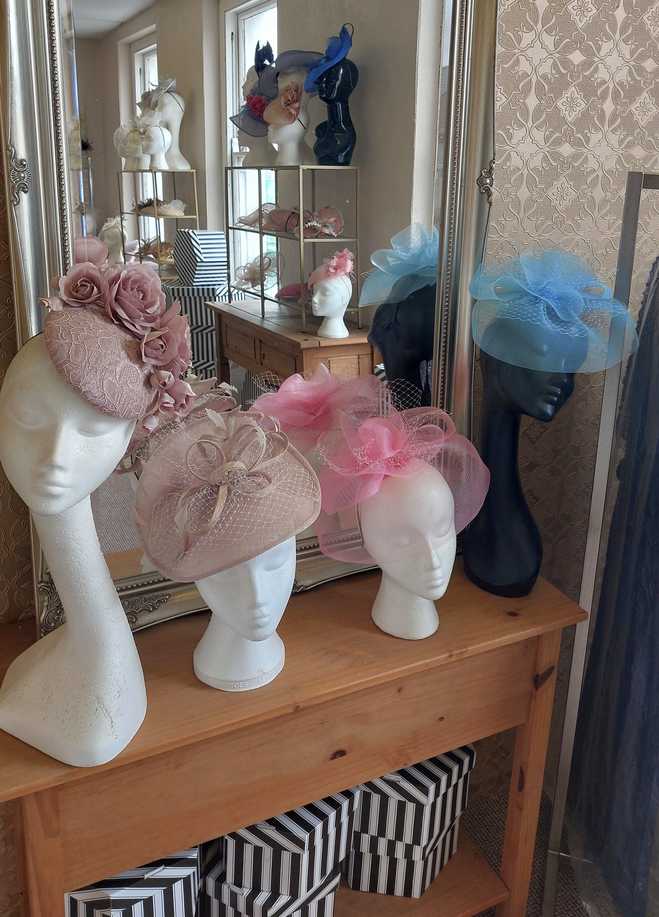 Display of decorative hats on mannequin heads in the John Paul Millinery showroom, derry