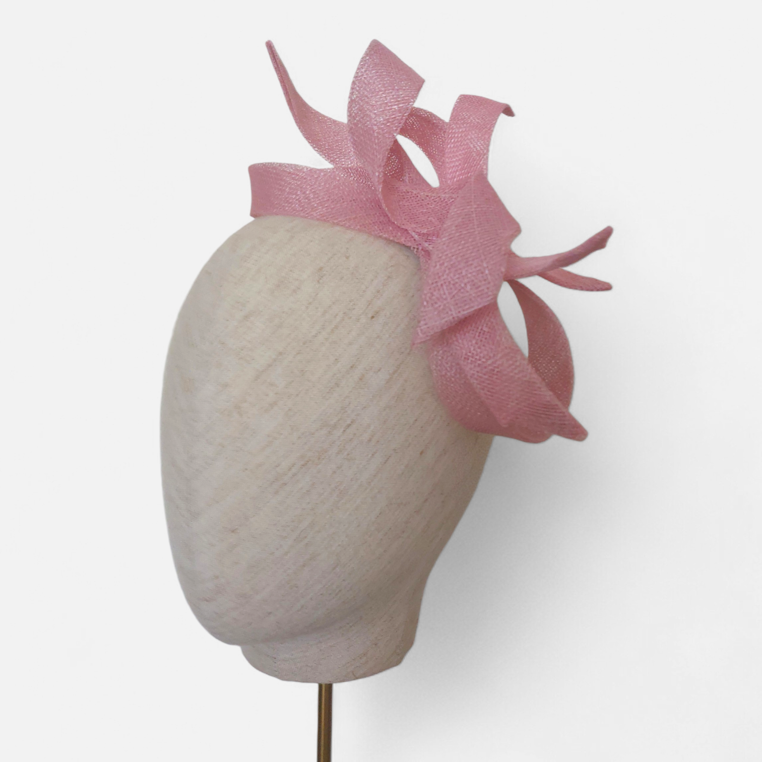 Decorative mannequin head with a pink looped bow John Paul Millinery headpice.