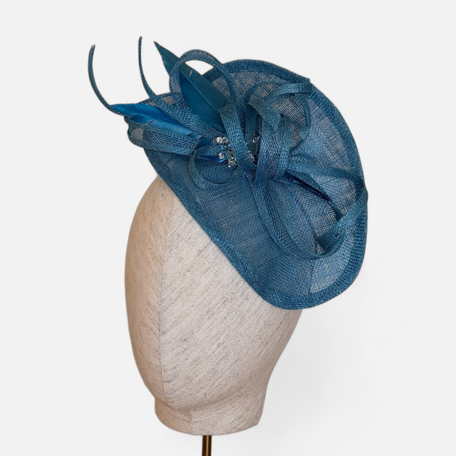 Aqua / teal fascinator hat with decorative feathers and veiling by John Paul Millinery