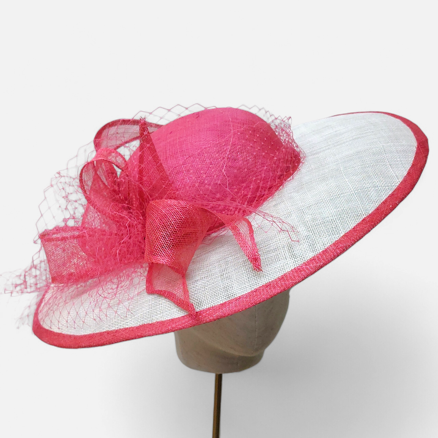 Pink and white hat with decorative veiling and loop detail, by John Paul Millinery