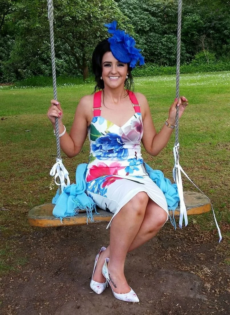 Guest relaxing on a swing wearing John Paul Millinery to a family wedding 