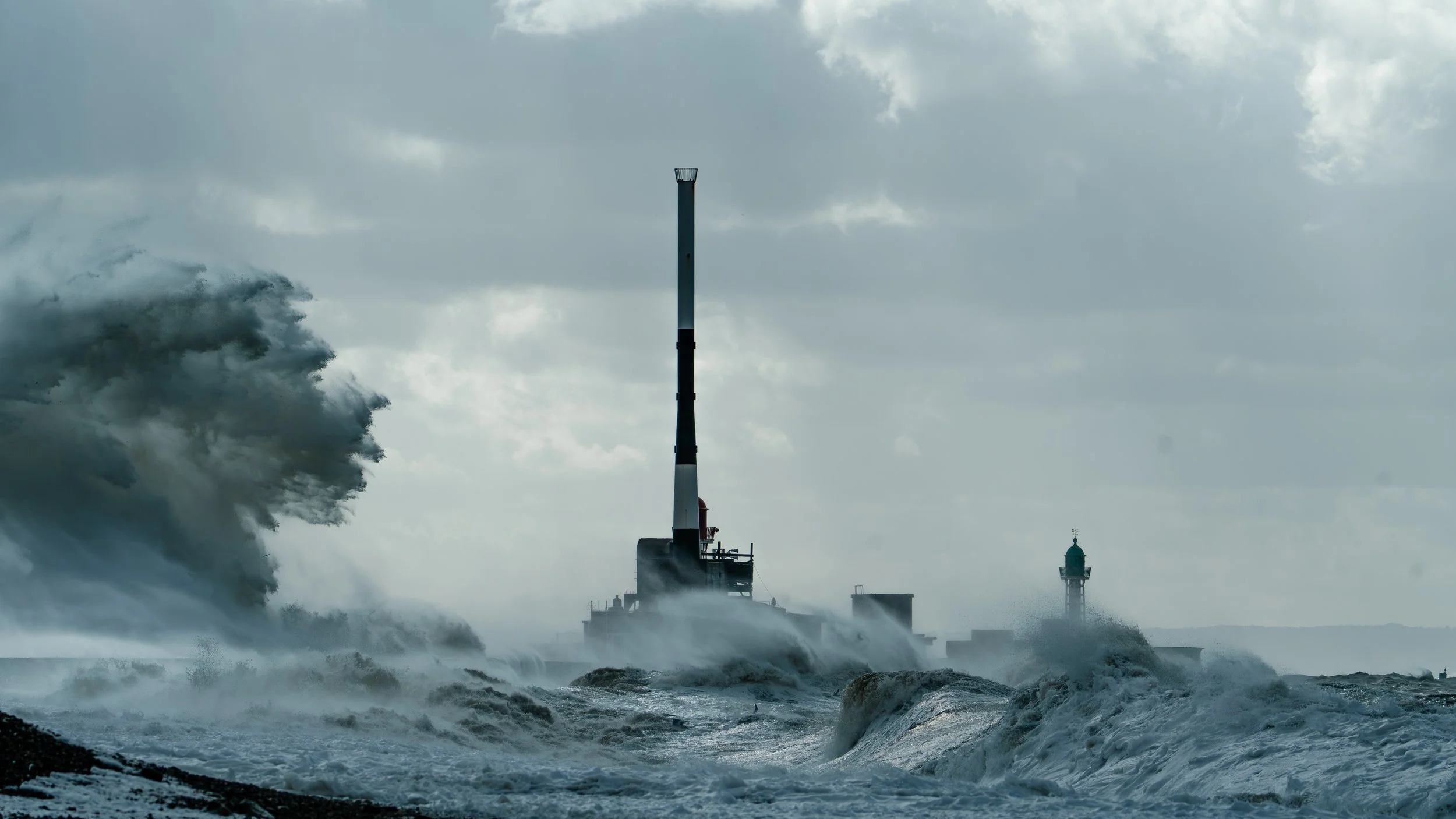 Forte mare in tempesta con onde alte e spruzzi, una piattaforma di ricerche con una torre di comunicazione, nuvole scure nel cielo.