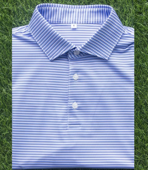 A blue and white striped button-up shirt lies folded on green grass.