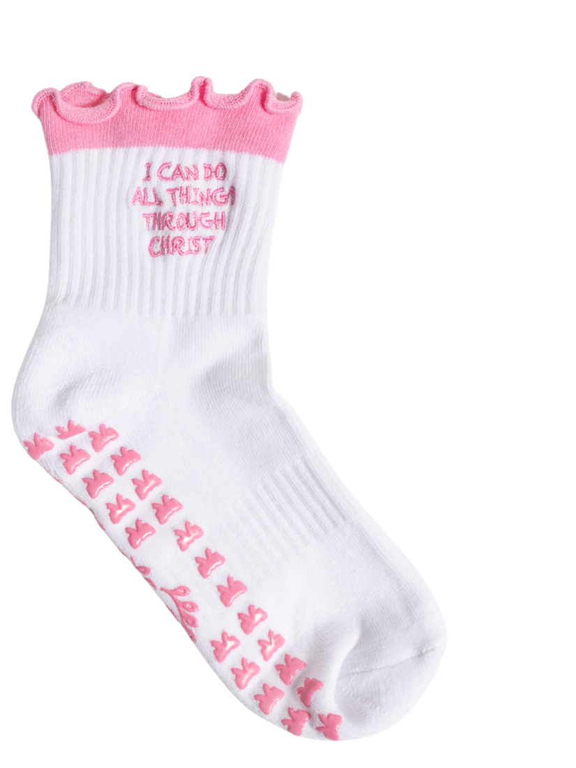 White sock with pink ruffled top, pink cross patterns on the sole, and the phrase 'I CAN DO ALL THINGS THROUGH CHRIST' embroidered on the side.