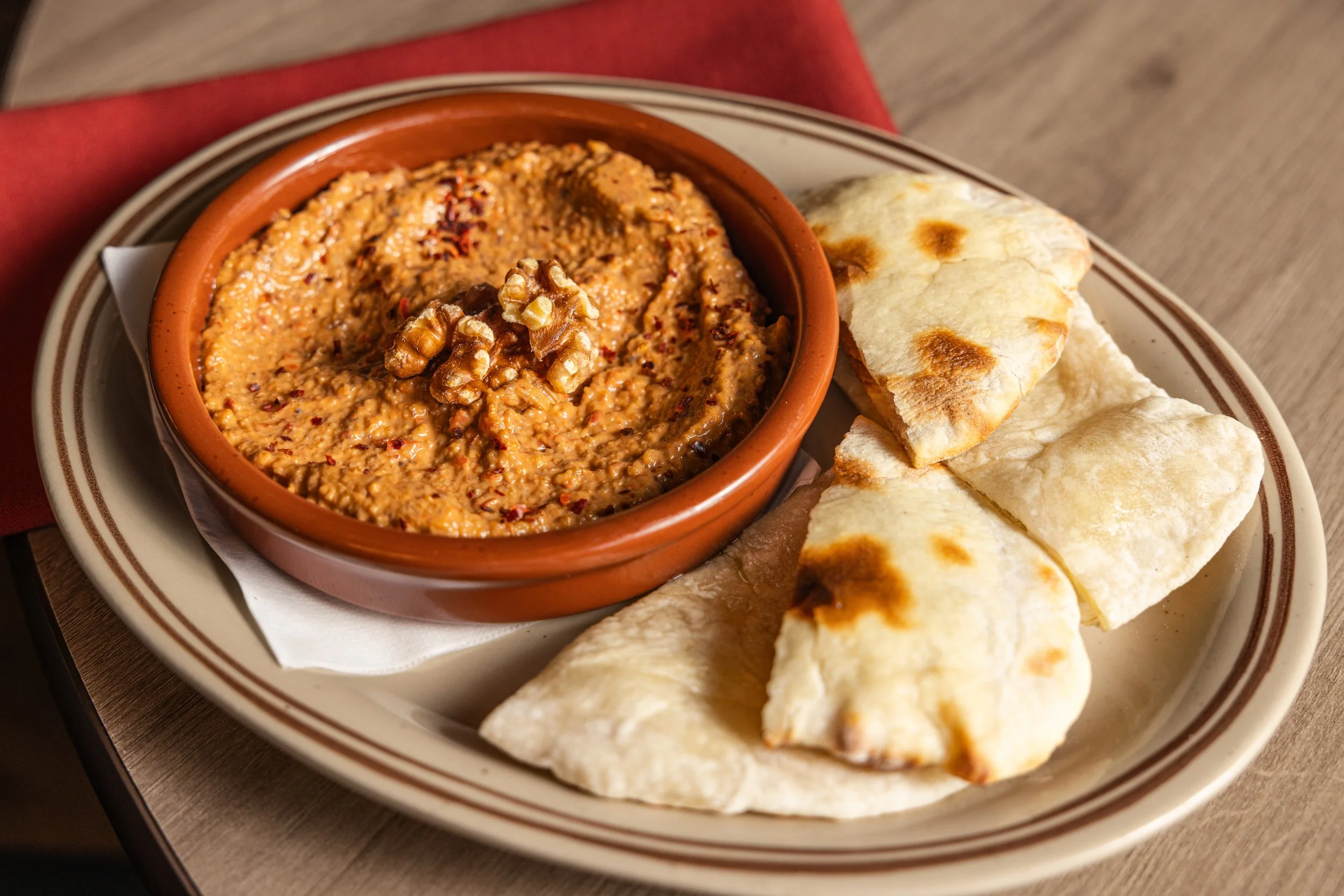 MUHAMMARA
Roasted peppers, walnuts, pomegranate molasses, warm flatbread (vg, tree nuts) · Syria