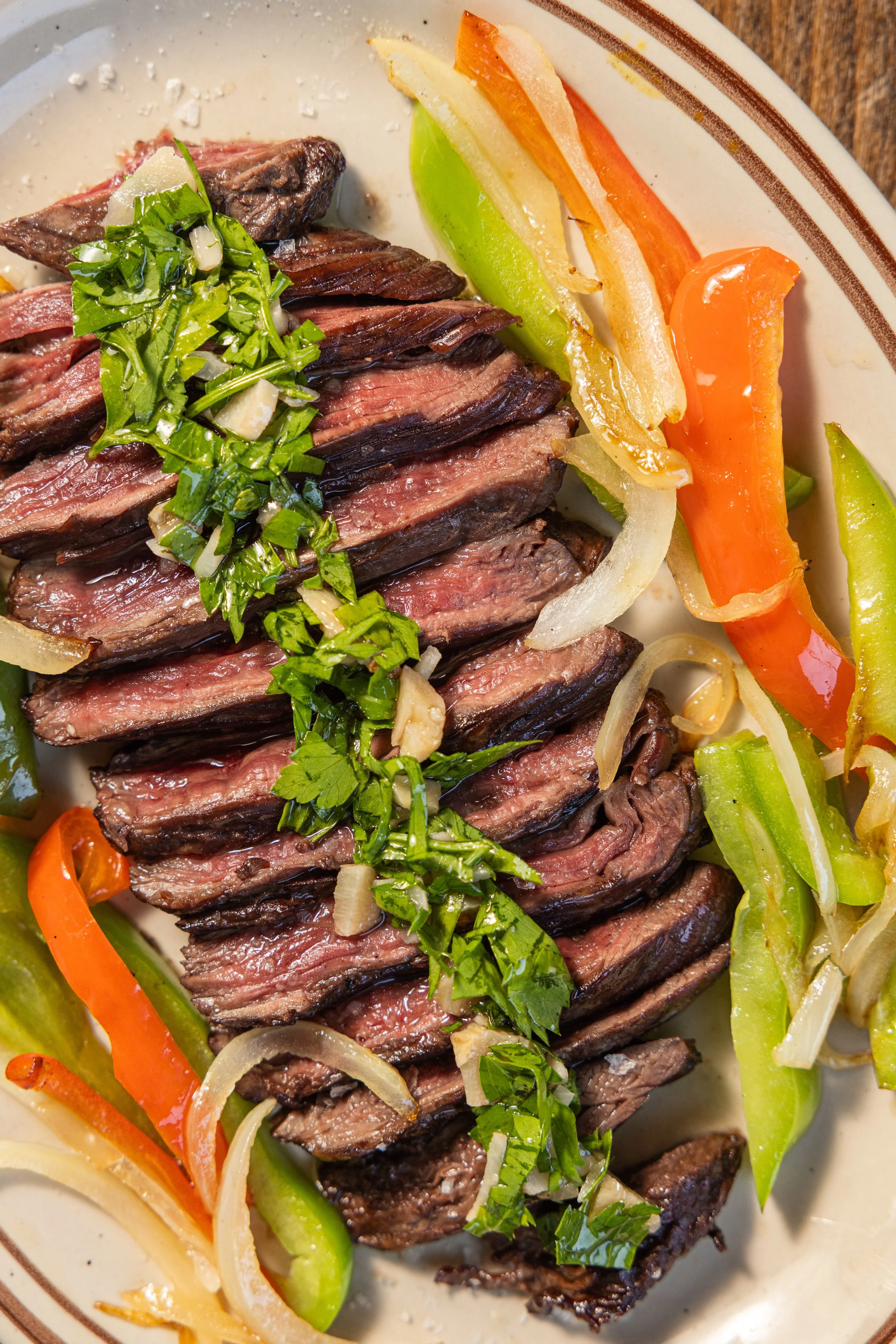 ENTRAÑA CON CHIMICHURRI
Charcoal-grilled skirt steak, charred peppers and onions, fresh chimichurri (gf) · Argentina