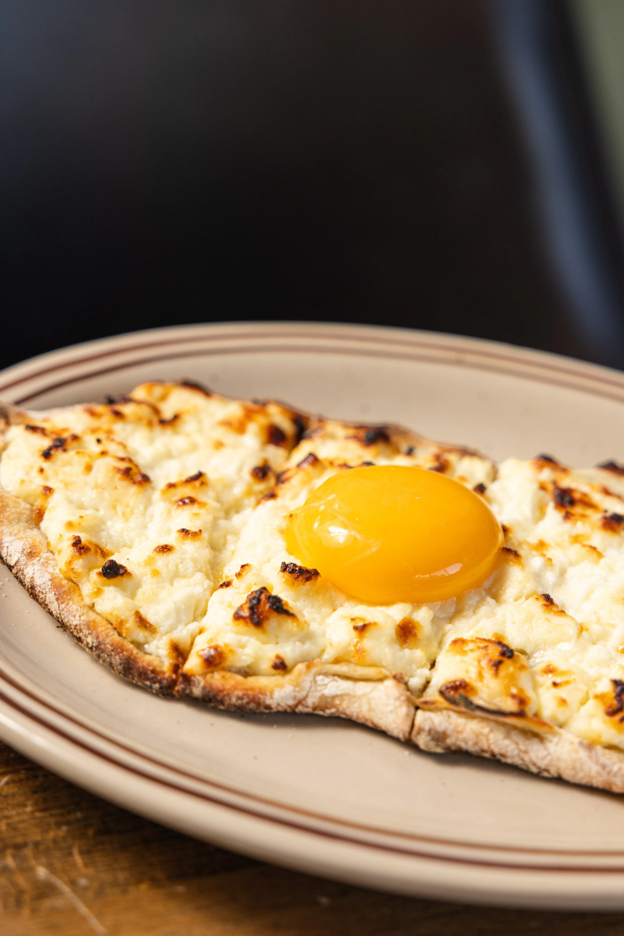 ADJARIAN KHACHAPURI
Boat-shaped Georgian cheese bread filled with melted cheese, butter and a soft-baked egg (v) · Georgia