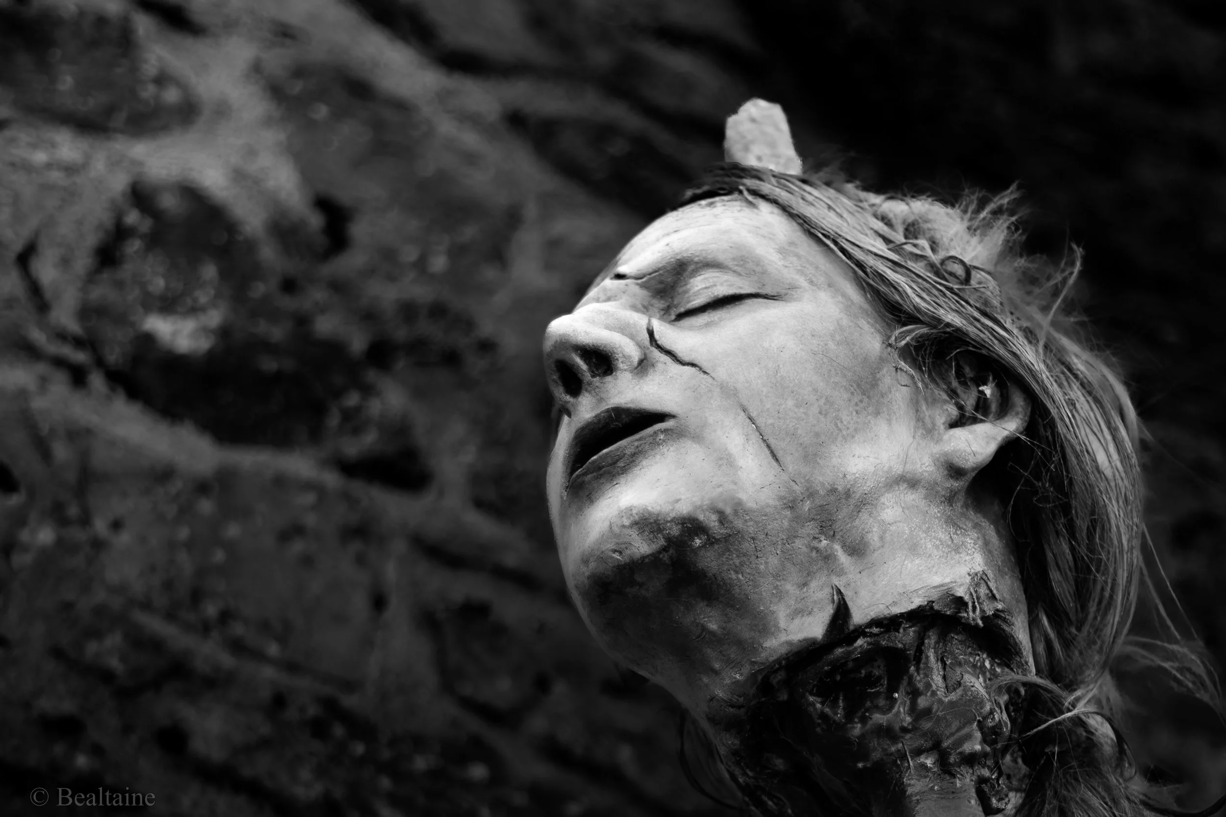 A human skull lying on the ground, partially buried in dirt, with a somber mood.