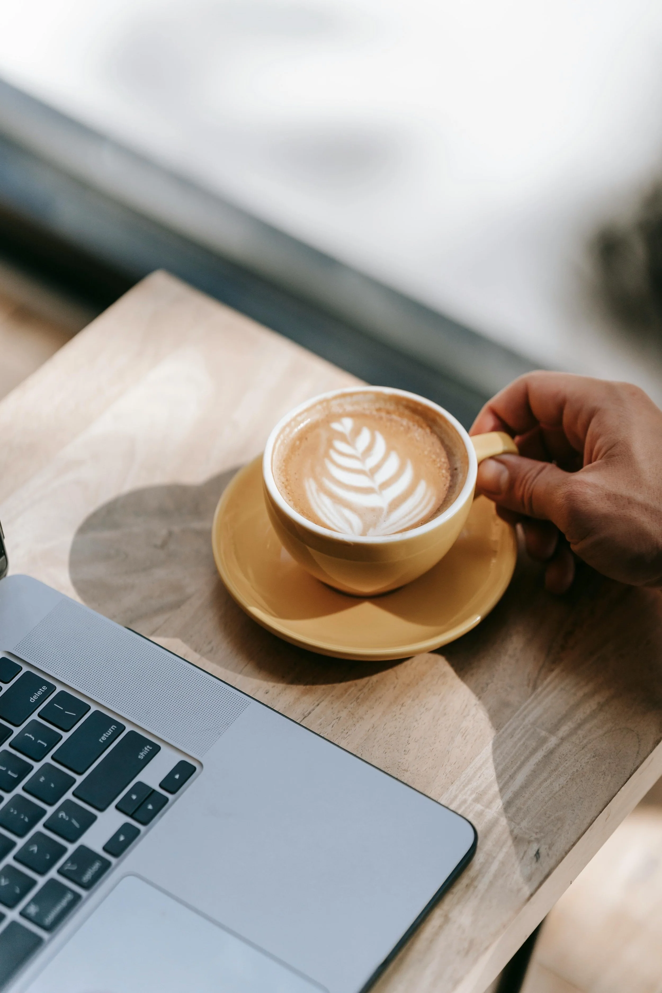 Hand holding a coffee mug during a virtual therapy session