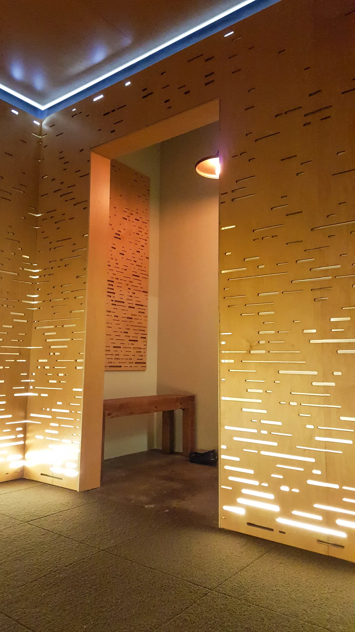 The meditation room,s doorway cuts through the etched plywood walls.