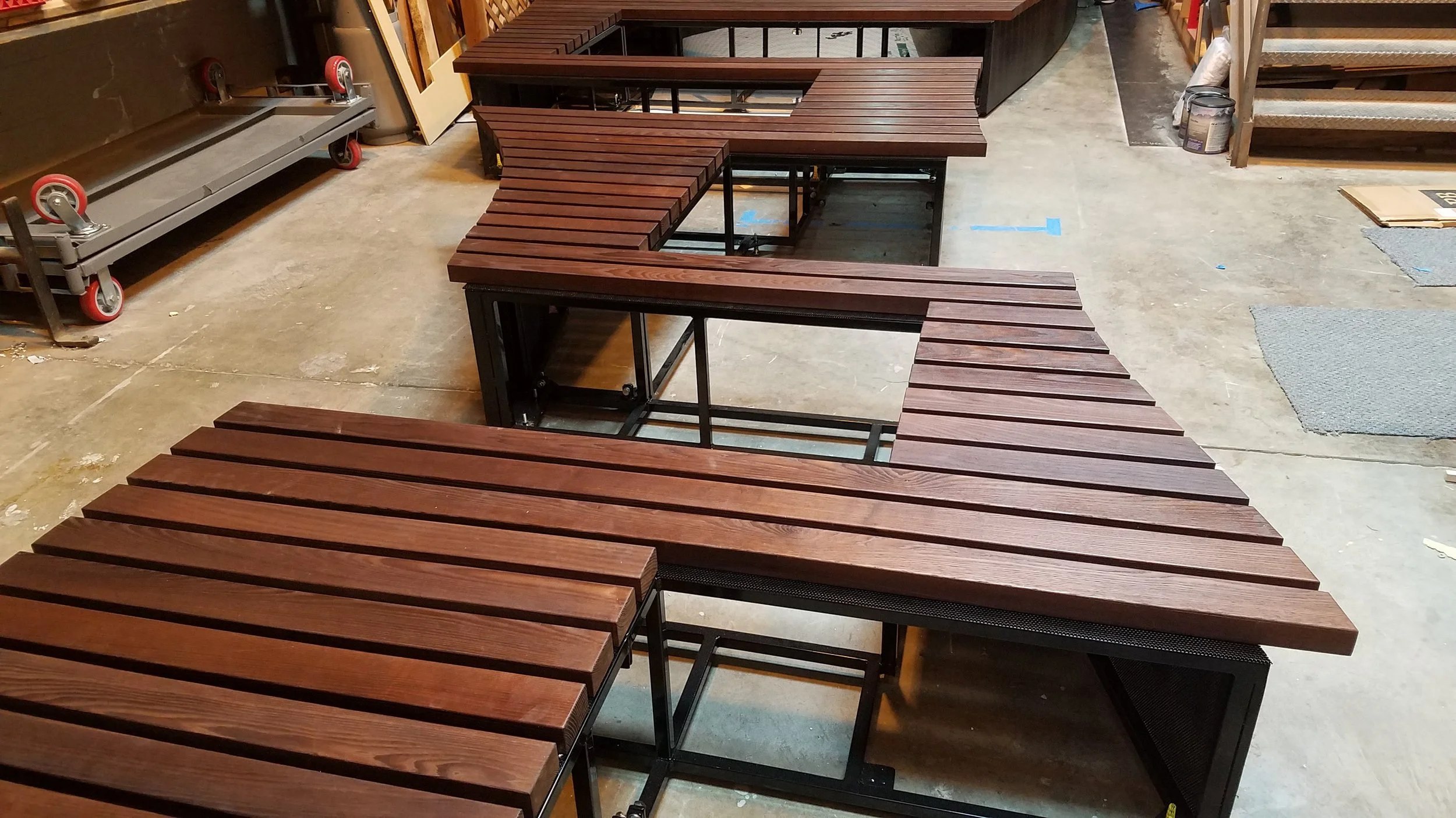 The bench surface is made from cedar slats, finished in a reddish brown stain.
