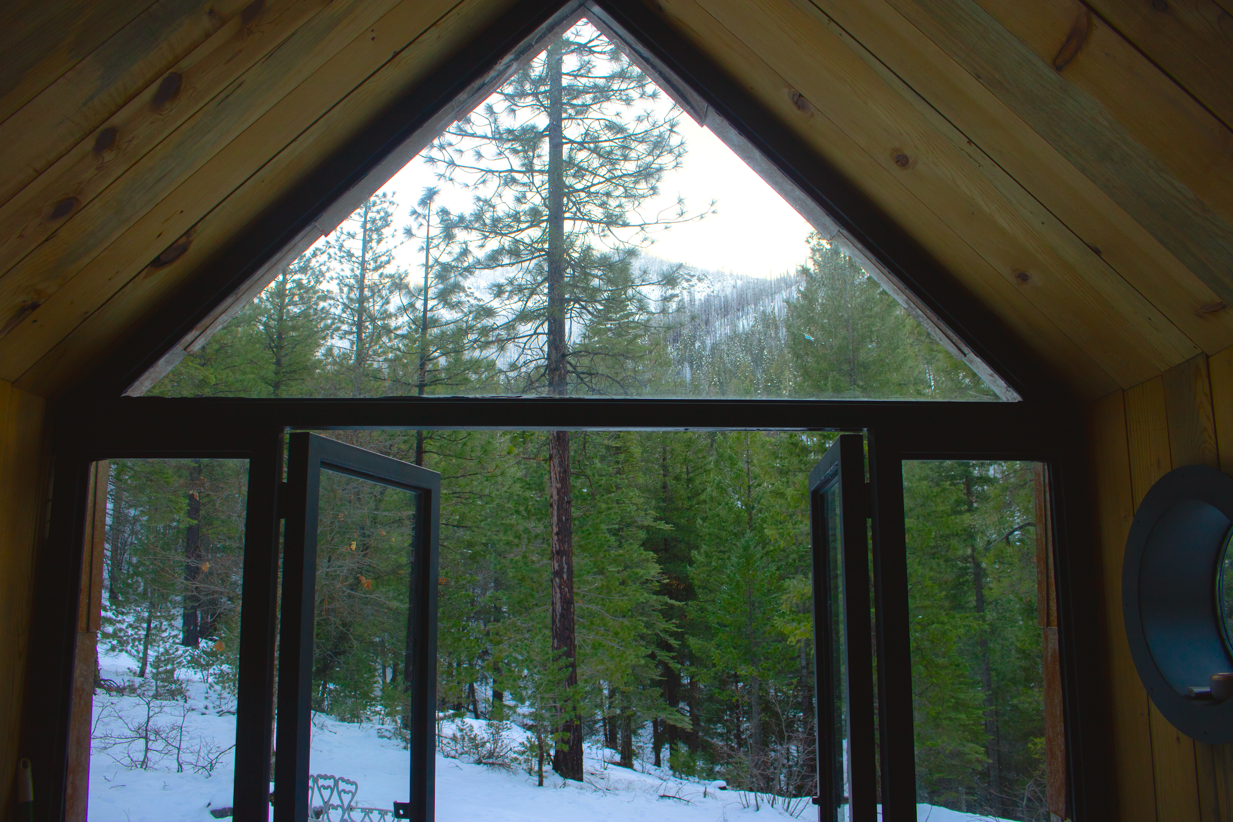 The triangular window, incased in black powdercoated steel, in the gable maximizes views of the snow-covered mountainside.