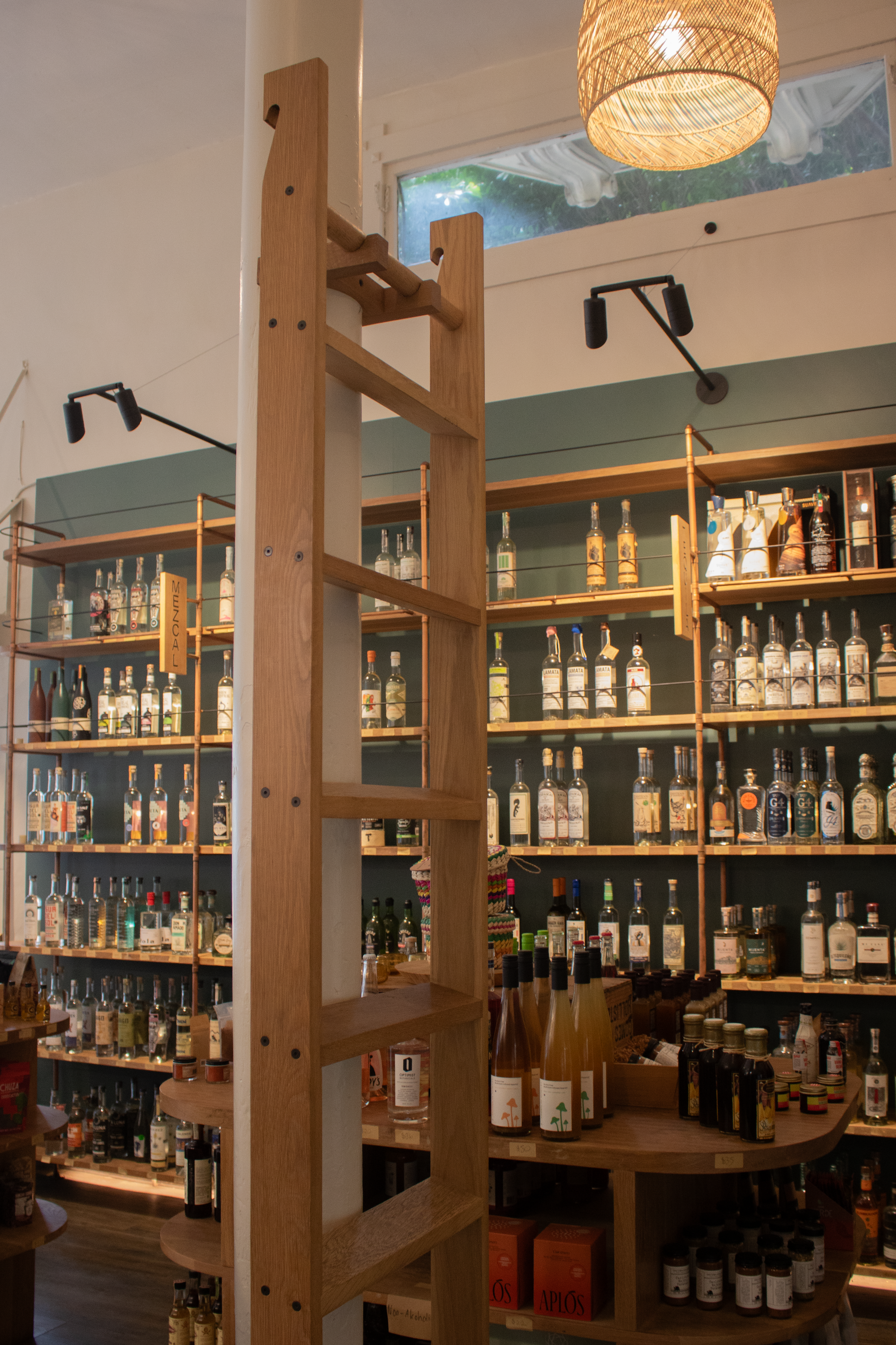 A removable ladder allows access to the top shelf bottles.