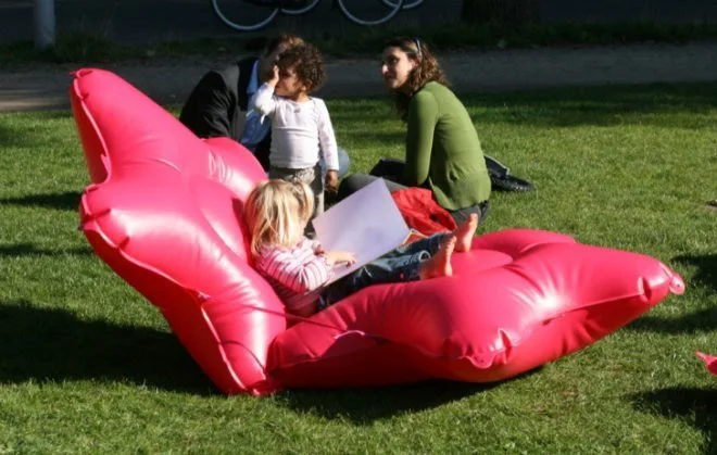 A young girl inspects her book, lounging on two star-shapped Bubbleware cushions.