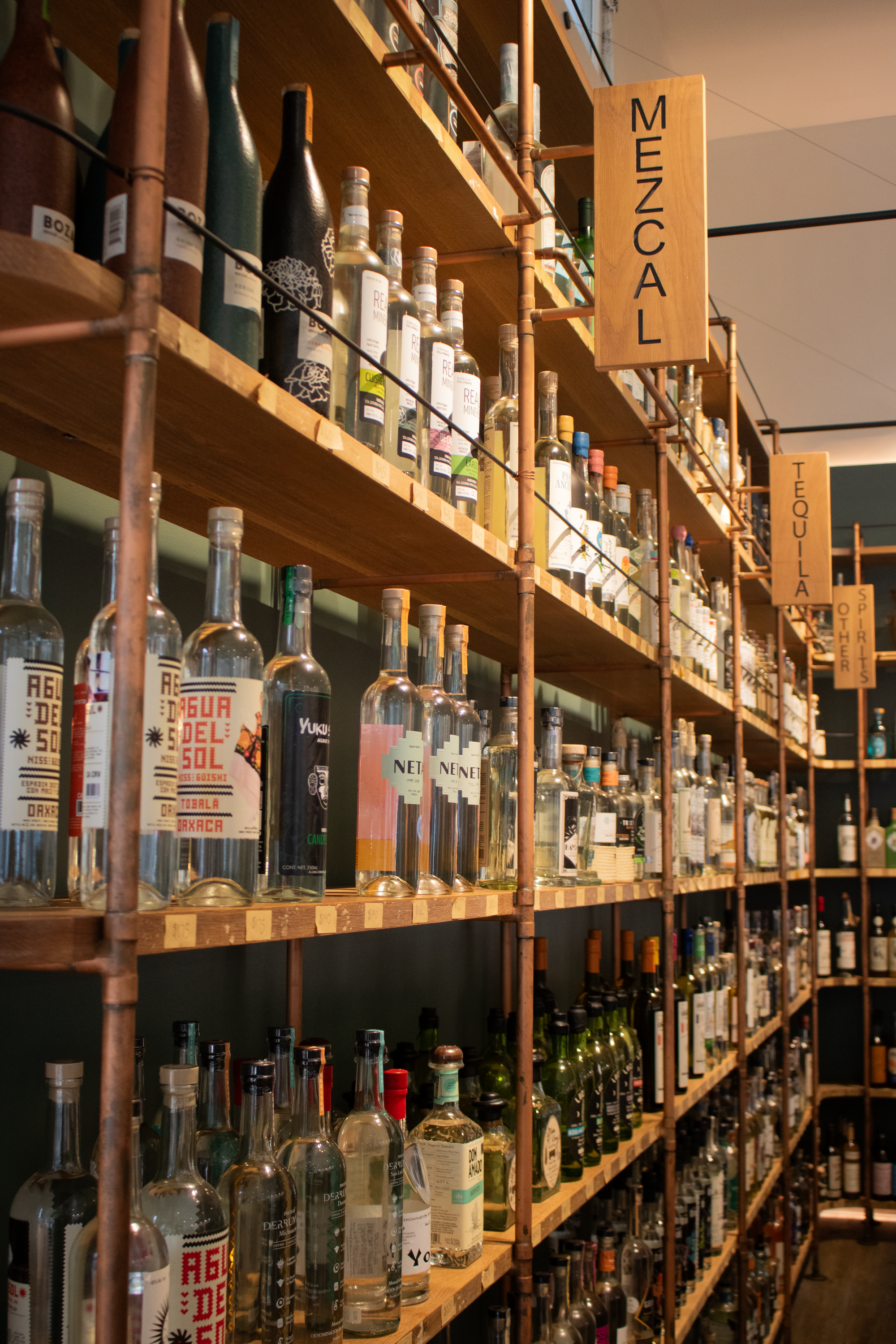 Tahon'as wide slection of spirits are displayed by a shelving system made from white birch and copper piping.