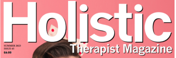 Close-up view of a magazine cover titled 'Holistic Therapist Magazine' with a pink background and partial view of a person's hair at the bottom.